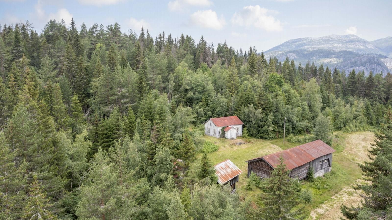 Eiendommen ligger skjermet og idyllisk til i Åsgrend i Kviteseid kommune Galleribilde