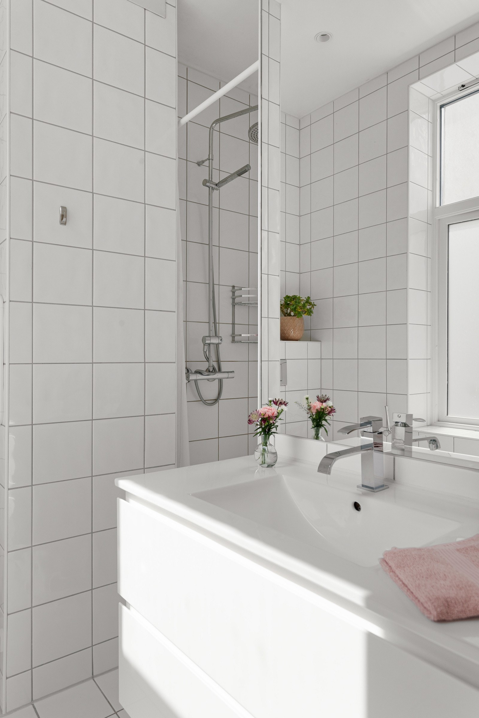 Badet er utstyrt med vegghengt wc, servant og dusj i hjørne. Galleribilde