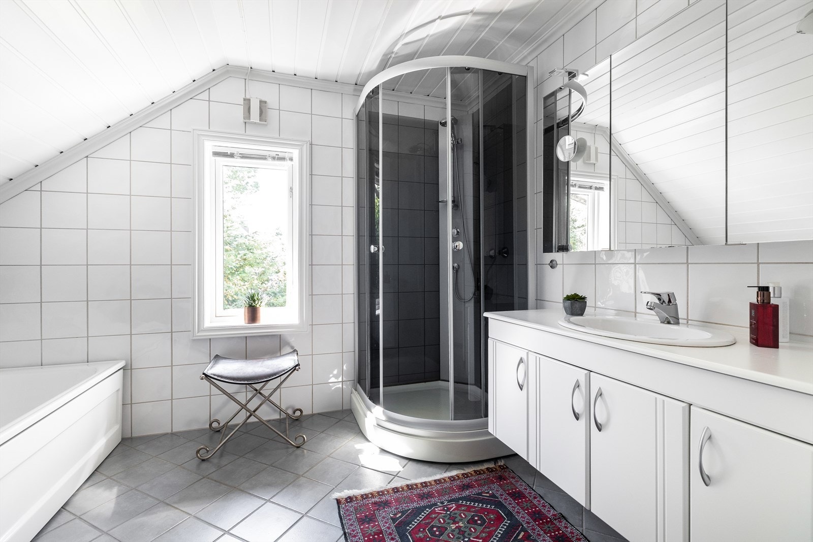 Romslig og flislagt bad med behagelig varme fra vannbåren gulvvarme Galleribilde