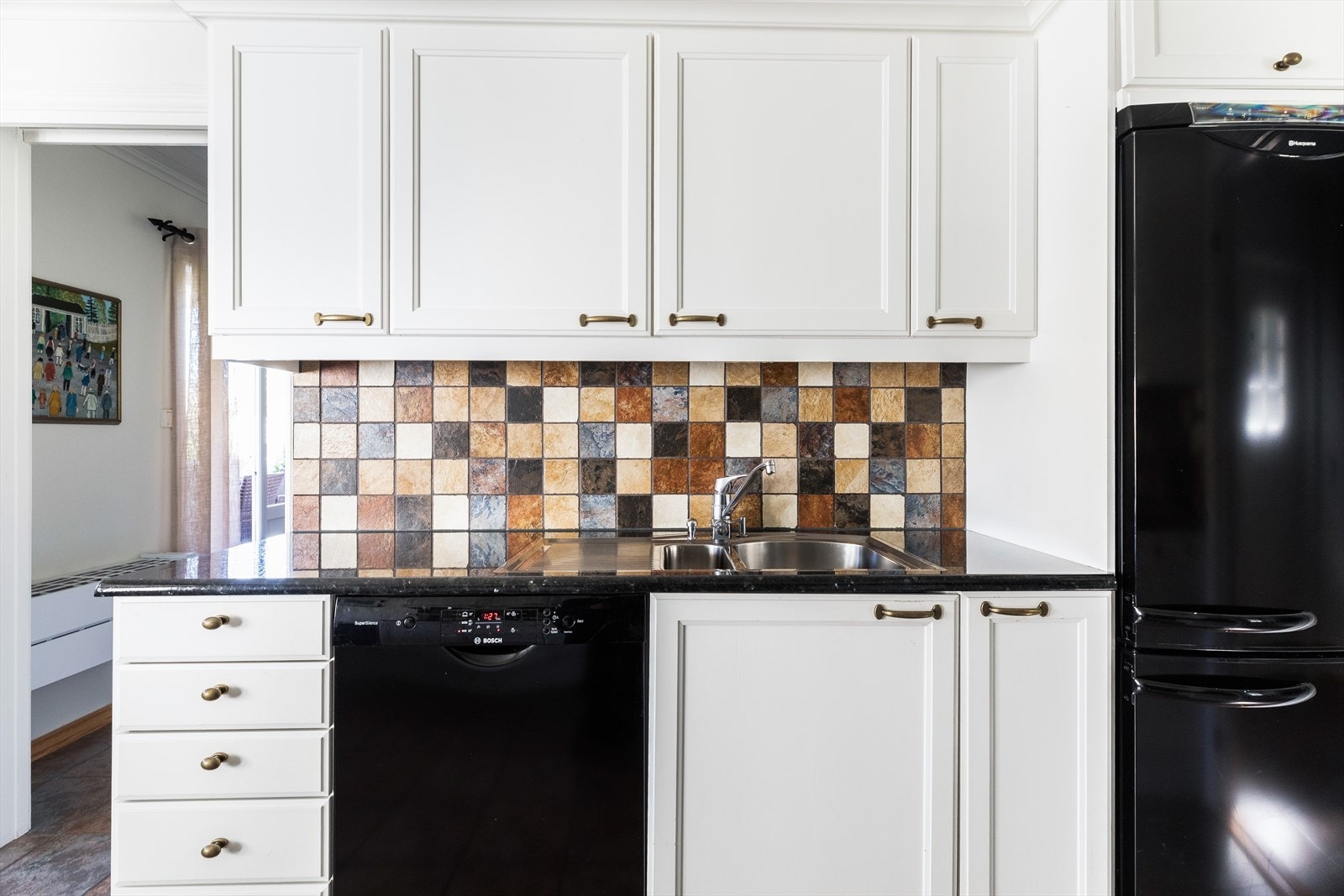 På kjøkken er det gulvfliser med vannbåren gulvvarme, malte tapetvegger og malt panel i tak Galleribilde