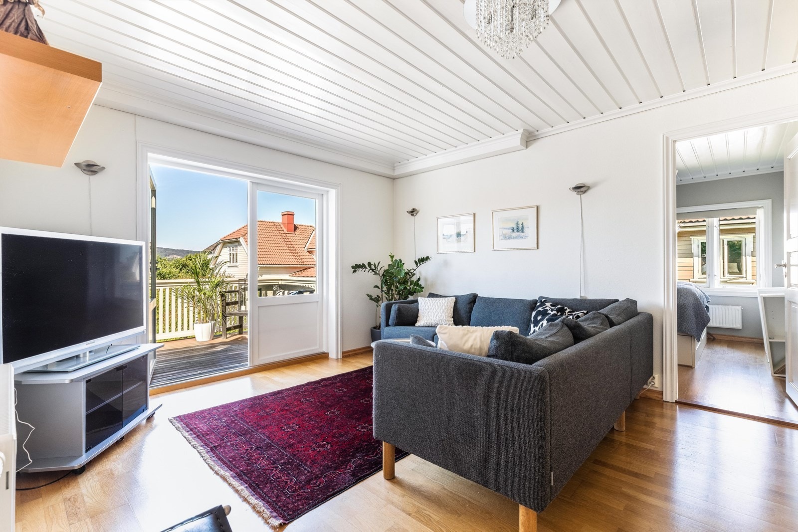 Stuen har lysmalte vegger, panel i himlingen og eikeparkett på gulv Galleribilde