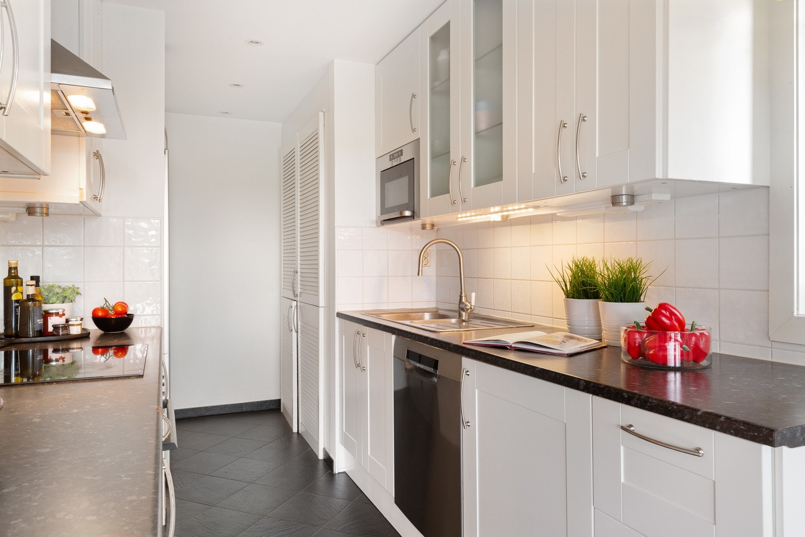 Kjøkkenet har rikelig med skap- og benkeplass, profilerte fronter og benkeplate i laminat, samt fliser mellom benk og overskap. Galleribilde