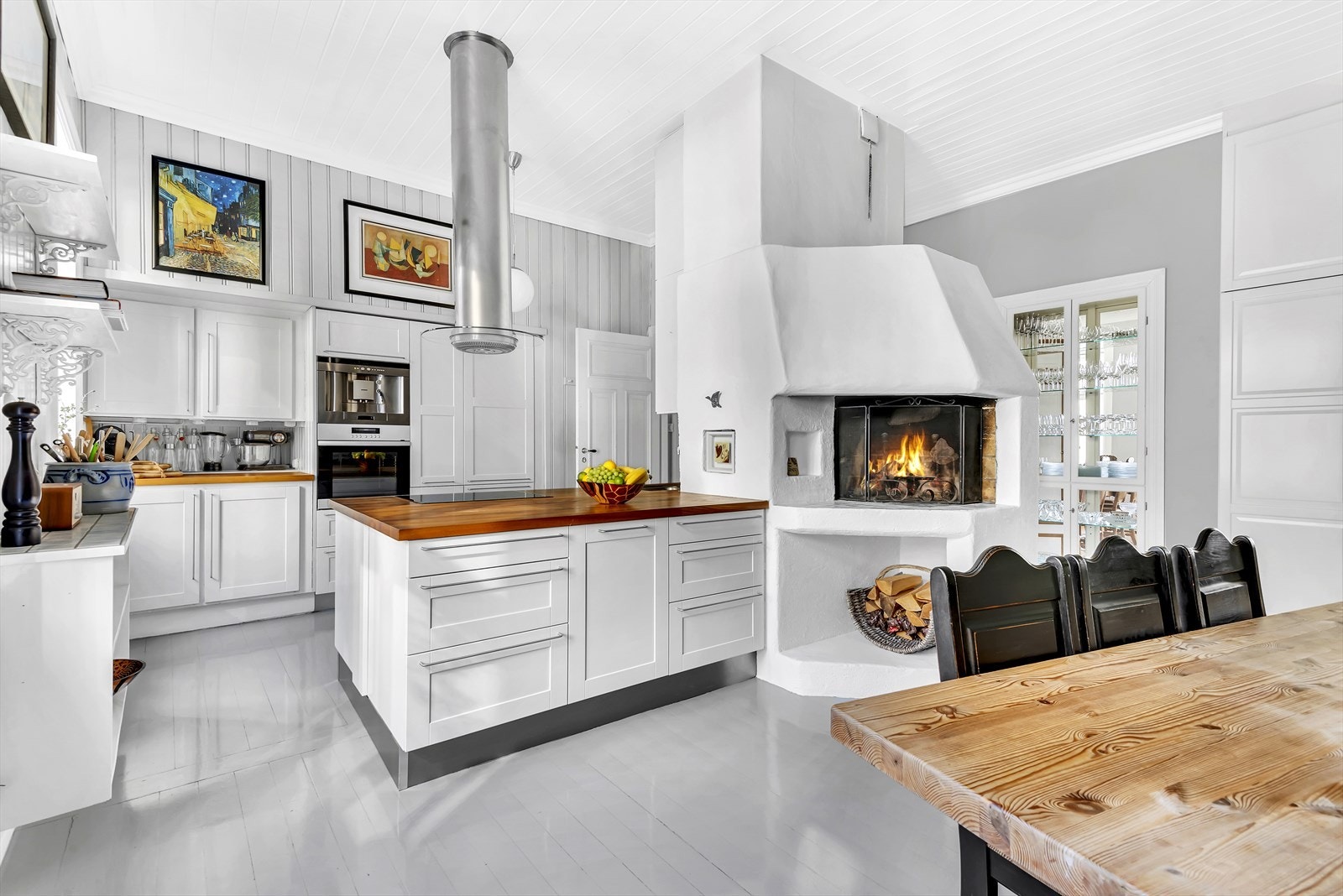 Lyst og romslig kjøkken/spisestue med åpen peis Galleribilde