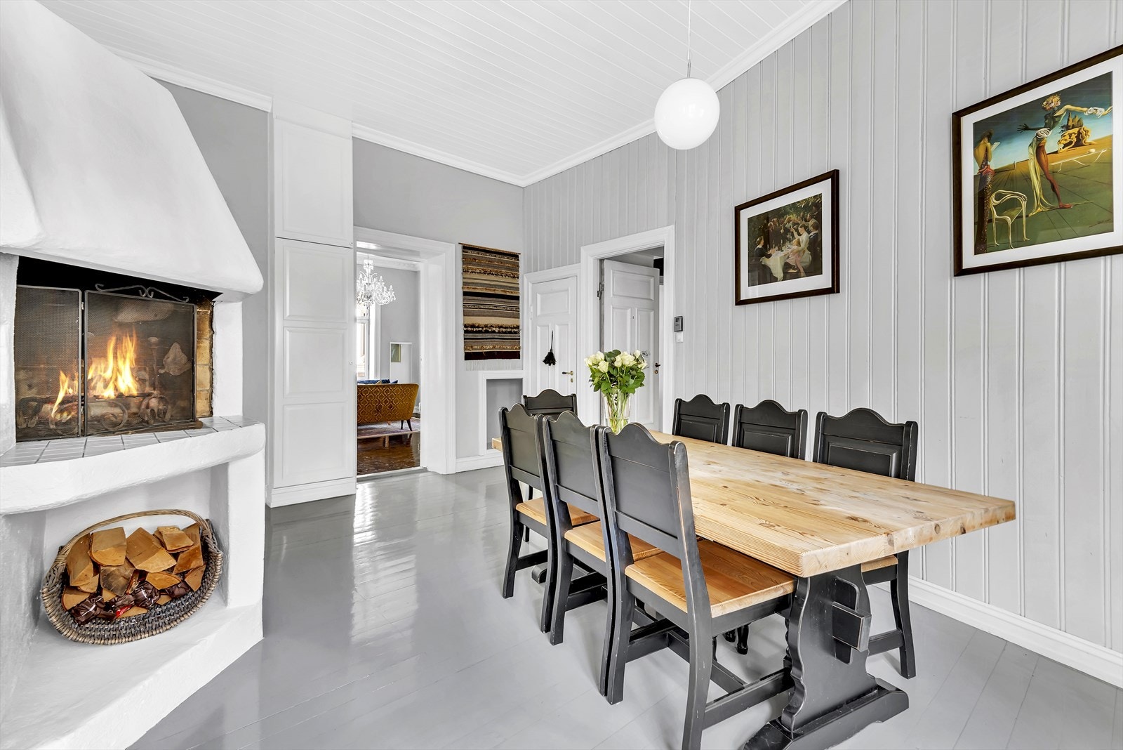 Spisestuen med peis i sammenheng med kjøkkenet gir et svært sosialt rom Galleribilde