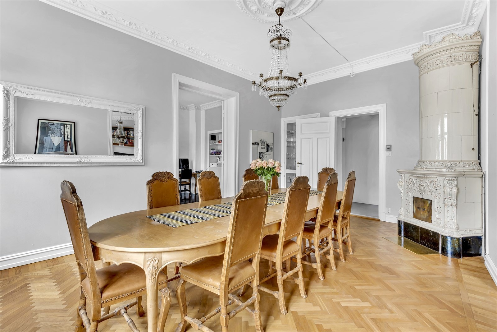 Leiligheten har 3 stuer på rad, alle med stukkaturer og rosetter - I denne stuen er det en flott kakkelovn Galleribilde