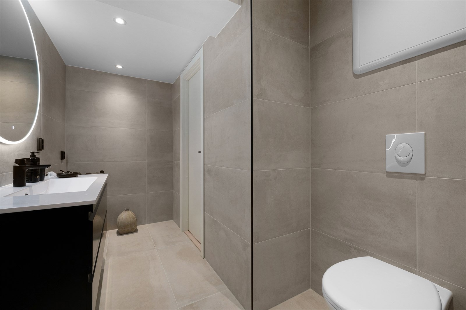 Vegghengt toalett, dusjhjørne, servant med innredning og speil Galleribilde