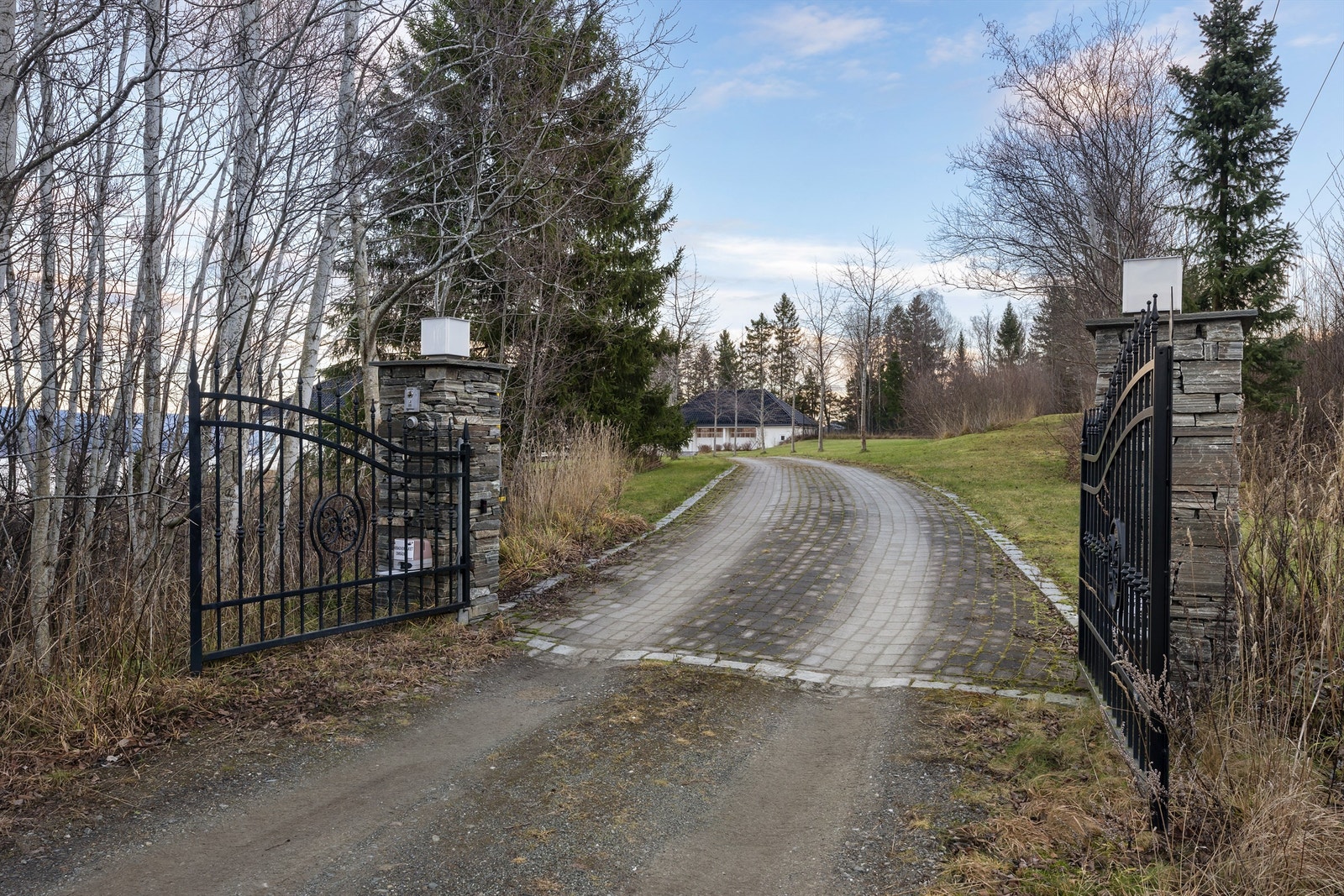 En nydelig smijernsport kan fjernstyres fra huset og avgrenser tomten inn mot alléen. Galleribilde