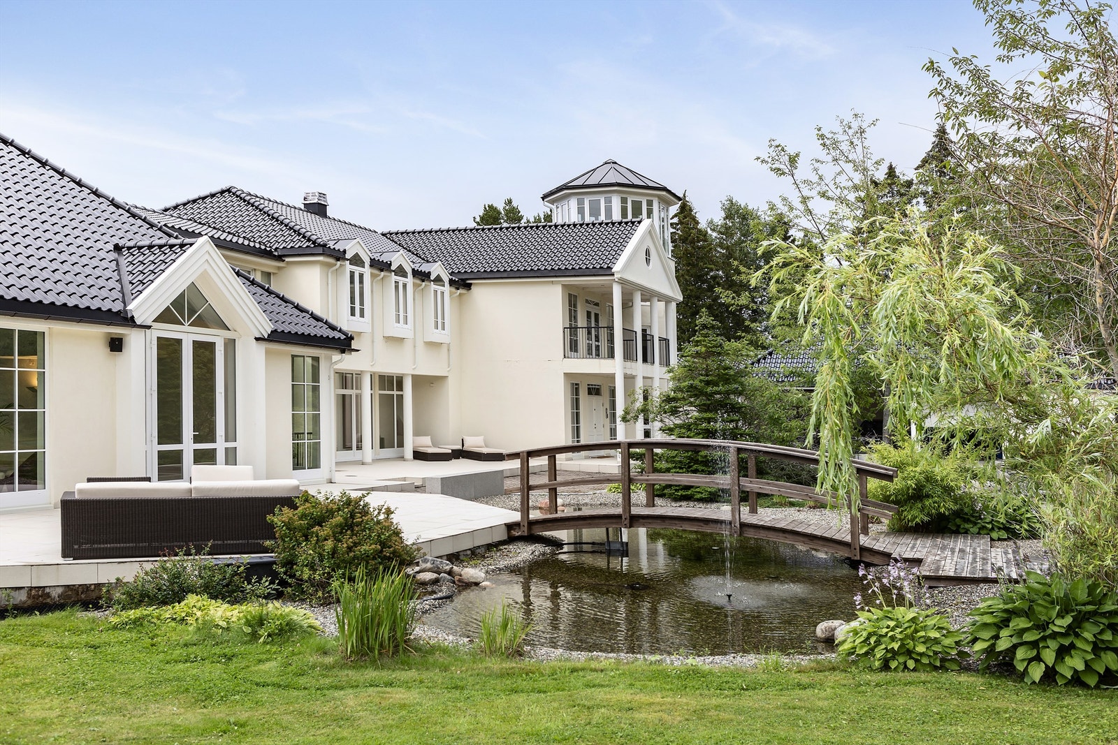 En karpedam sørger for ekstra stemning, med bro fra gårdsplass til deilig terrasse. Galleribilde