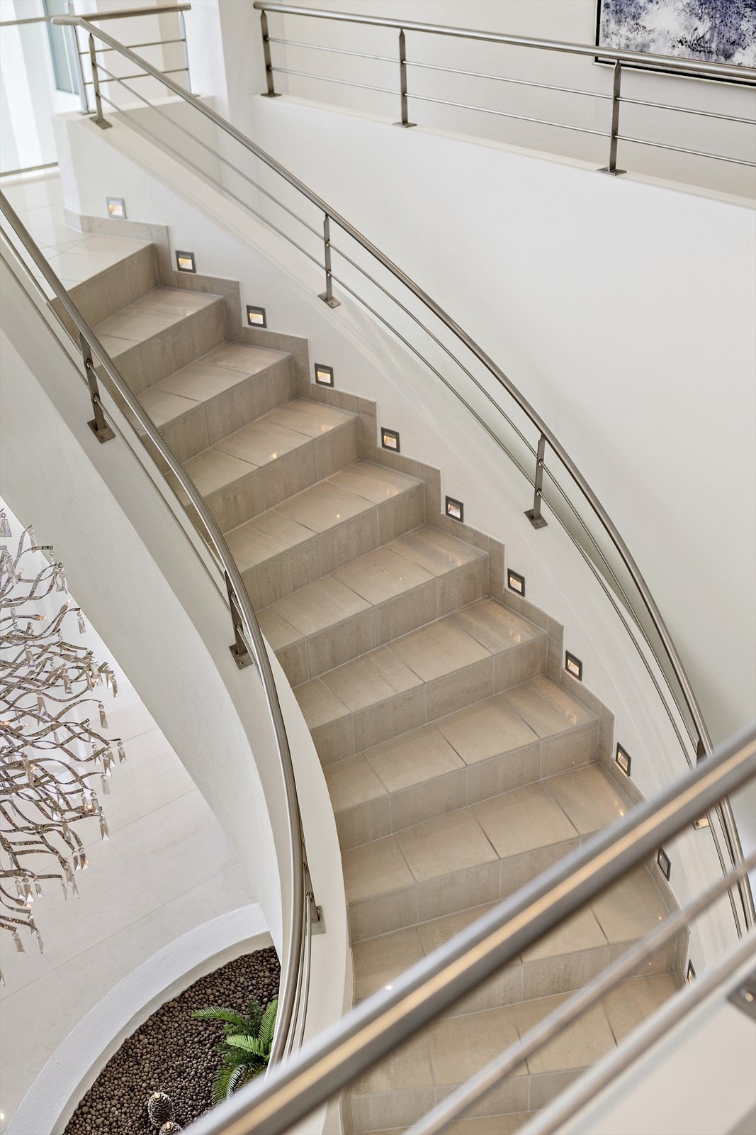 En lekker, flislagt trapp slynger seg opp til andre etasje med mastersuite, gjestefløy og loftstue. Galleribilde