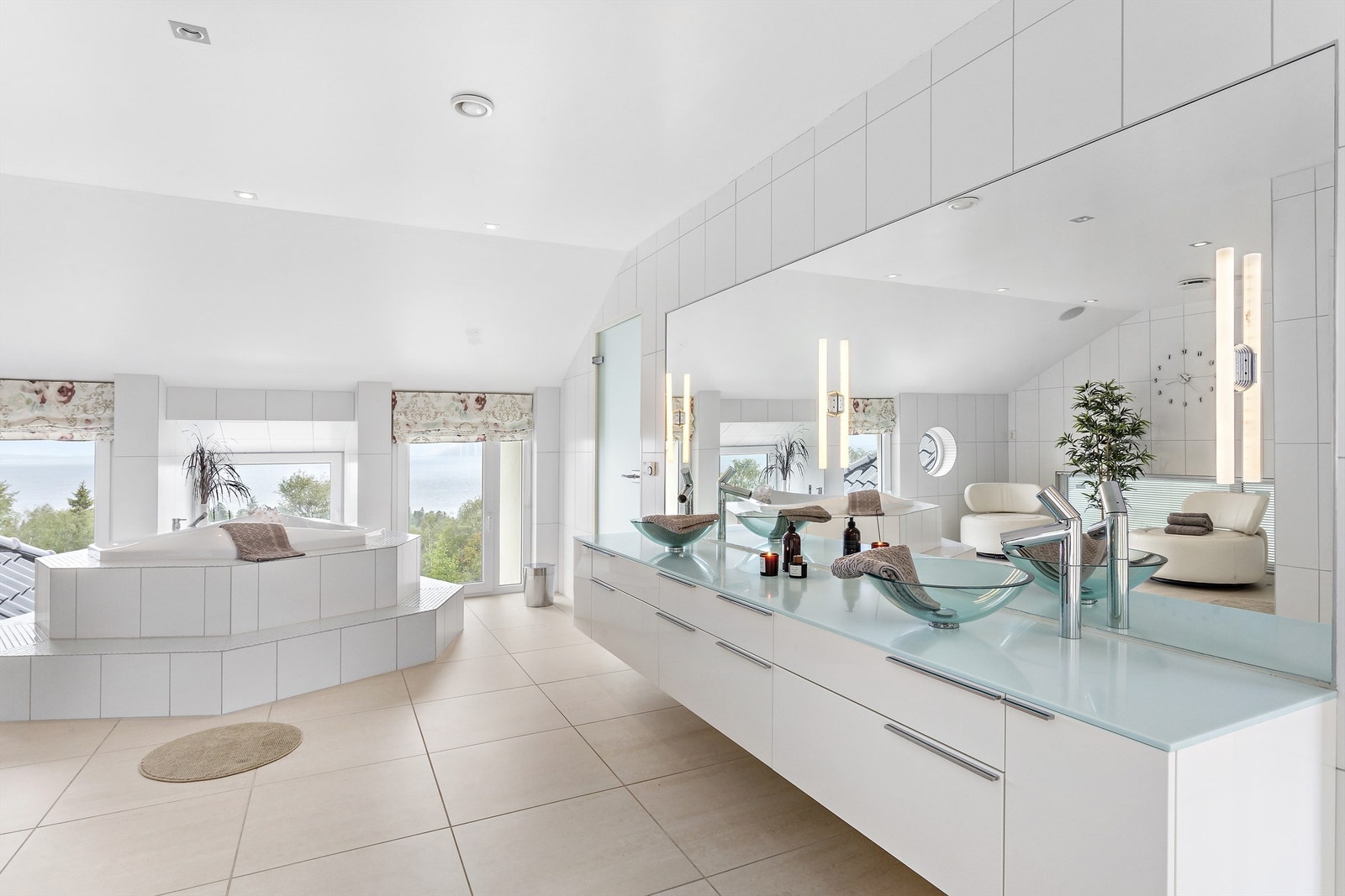 Spabadet er stort og lyst med badekar, dusj, lekker innredning og nydelig fjordutsikt. Galleribilde