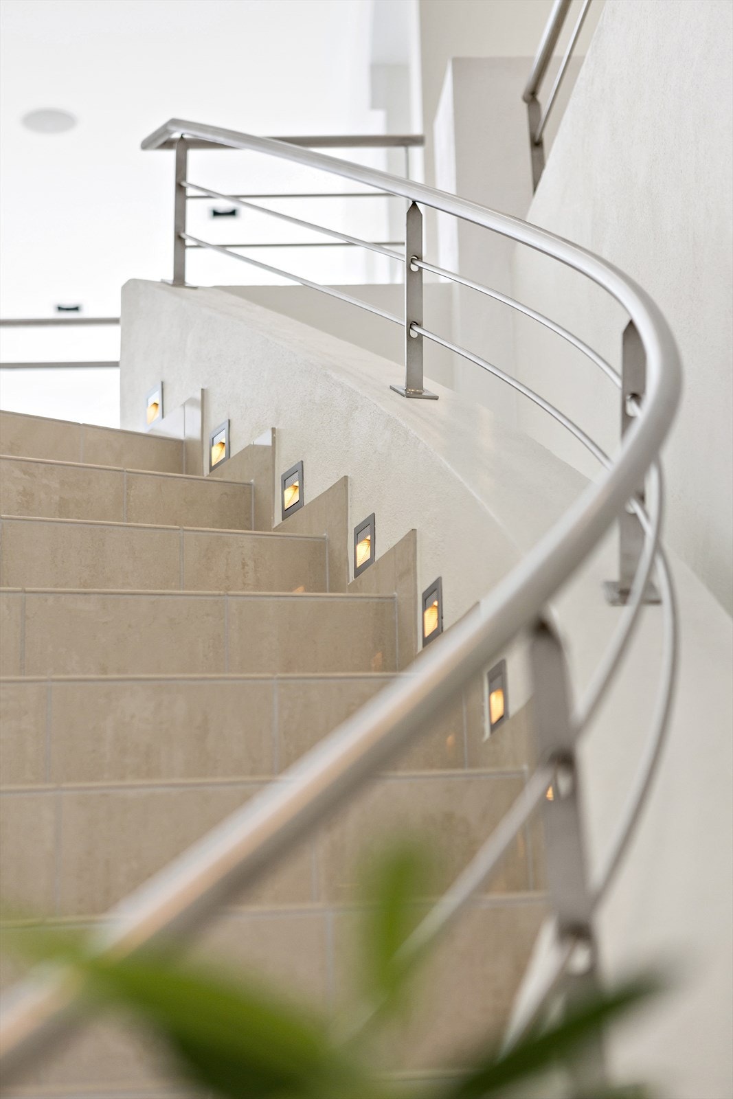 En lekker, flislagt trapp slynger seg opp til andre etasje med mastersuite, gjestefløy og loftstue. Galleribilde