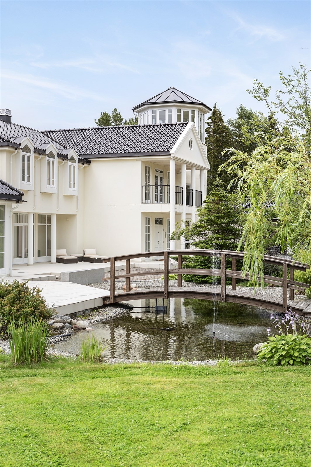 Karpedam med bro fra gårdsplass til terrasse. Galleribilde