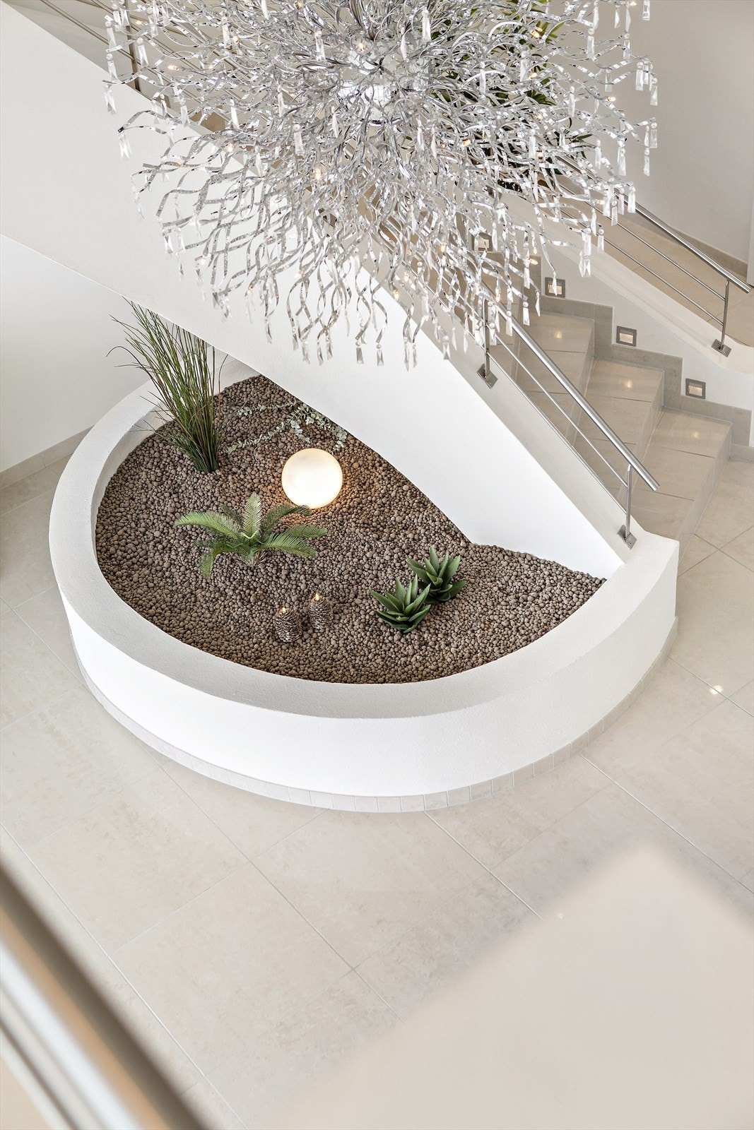 En lekker, flislagt trapp slynger seg opp til andre etasje med mastersuite, gjestefløy og loftstue. Galleribilde