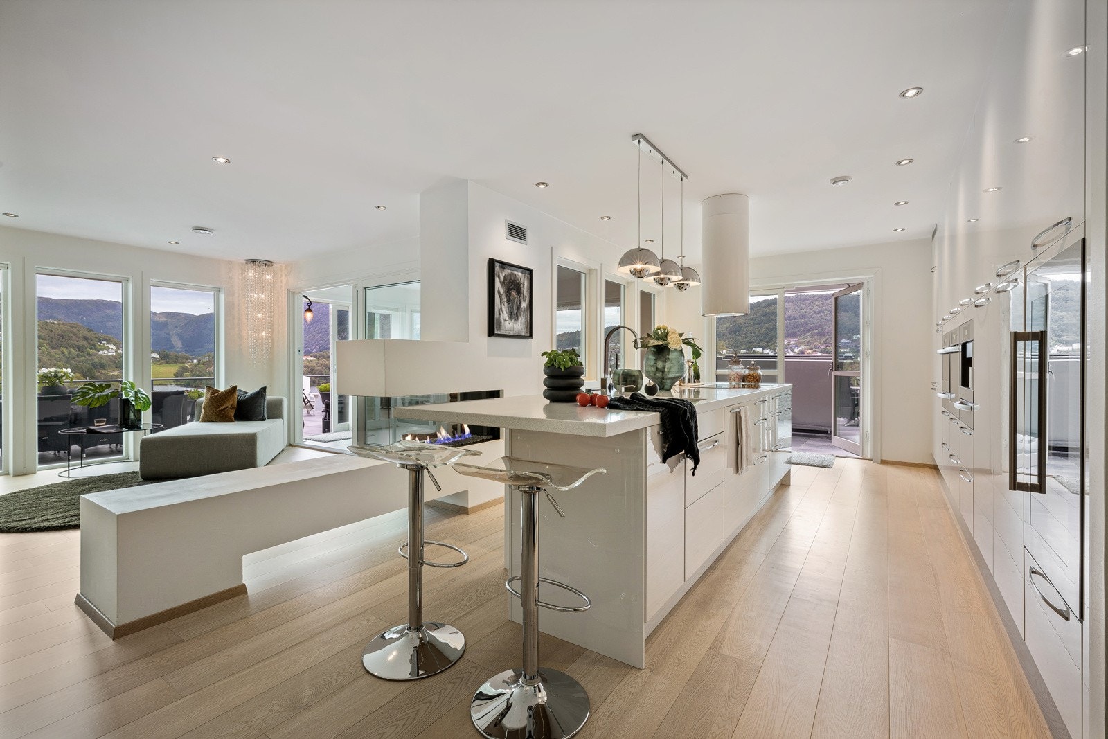 Peisen gjør også at stue og kjøkken deles opp i ulike "soner", samtidig som det er luftig og åpent Galleribilde