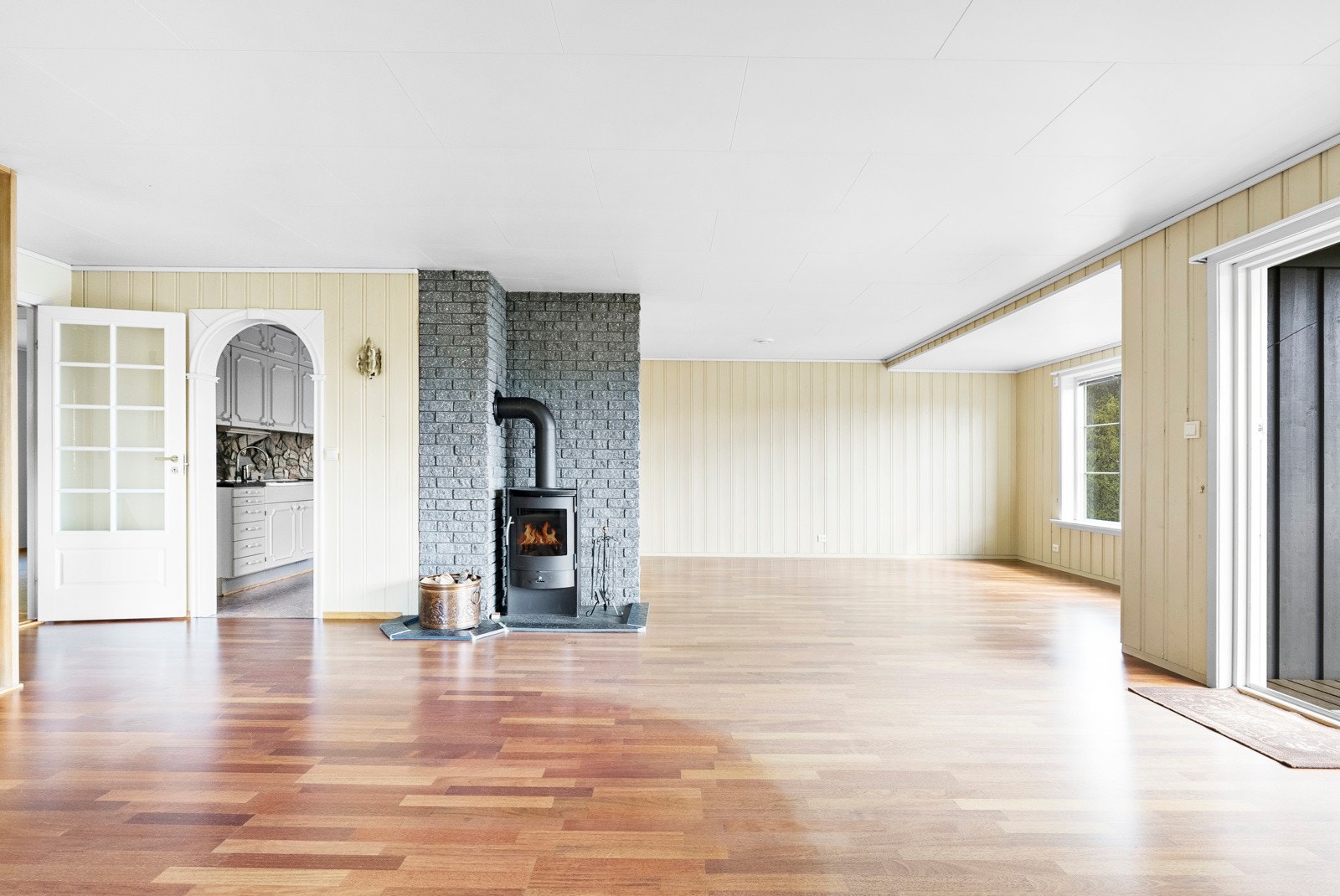 Rommet fremgår i lyse og nøytrale farger, og får inn mye naturlig lys fra de store vindusflatene. I stuen er det installert både vedovn og varmepumpe. Galleribilde