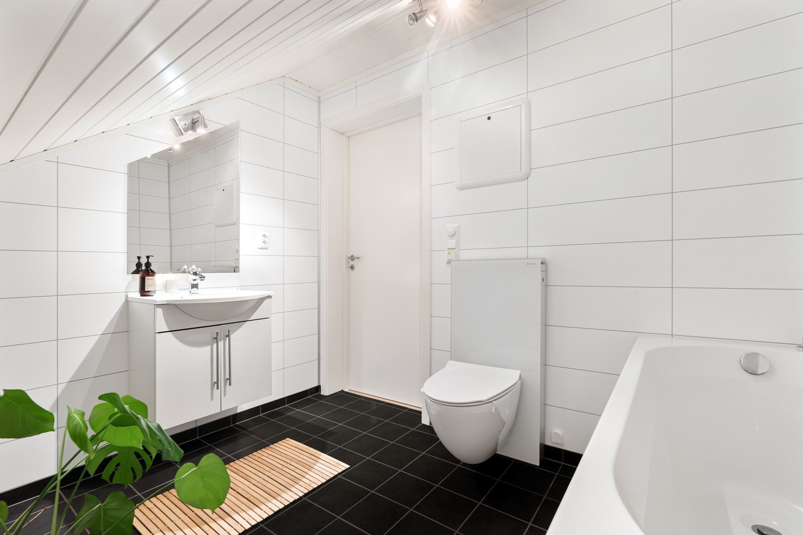 Boligen har totalt 3 baderom. Her er badet som ligger i 2.etasje. Utstyrt med badekar, vegghengt toalett og servant med underskap