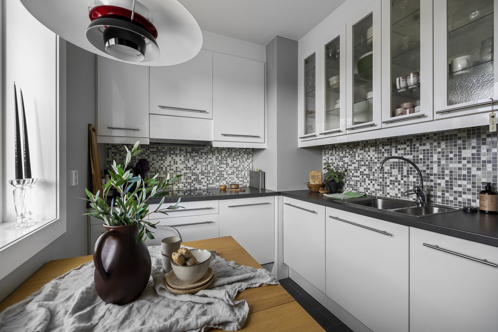 Fine, lyse fronter med høye skap. Fliser mellom skap. Plass til et hyggelig frokostbord Galleribilde