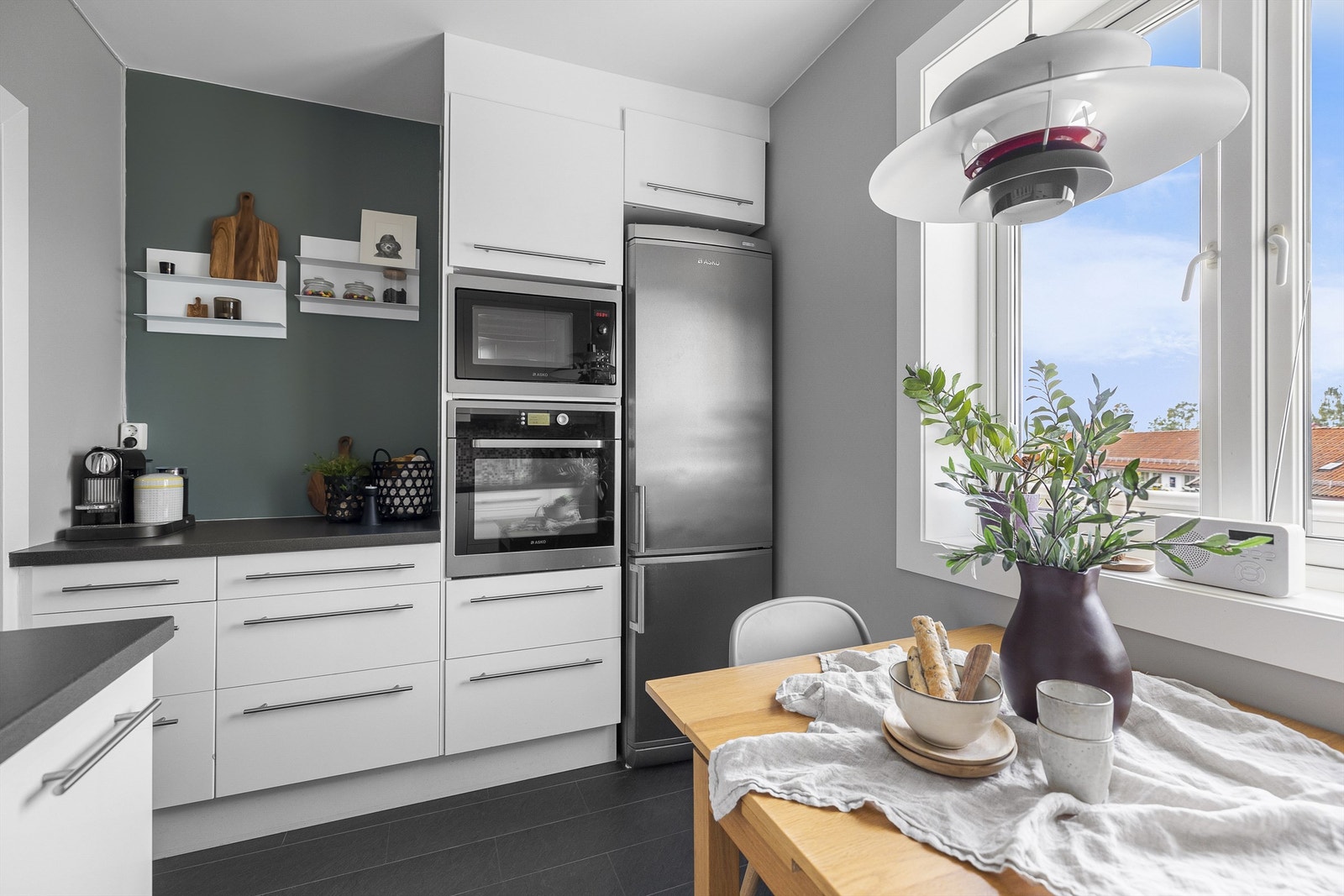 Kjøkkenet oppleves romslig med god skapplass, integrerte hvitevarer, moderne fargevalg og godt med lys Galleribilde