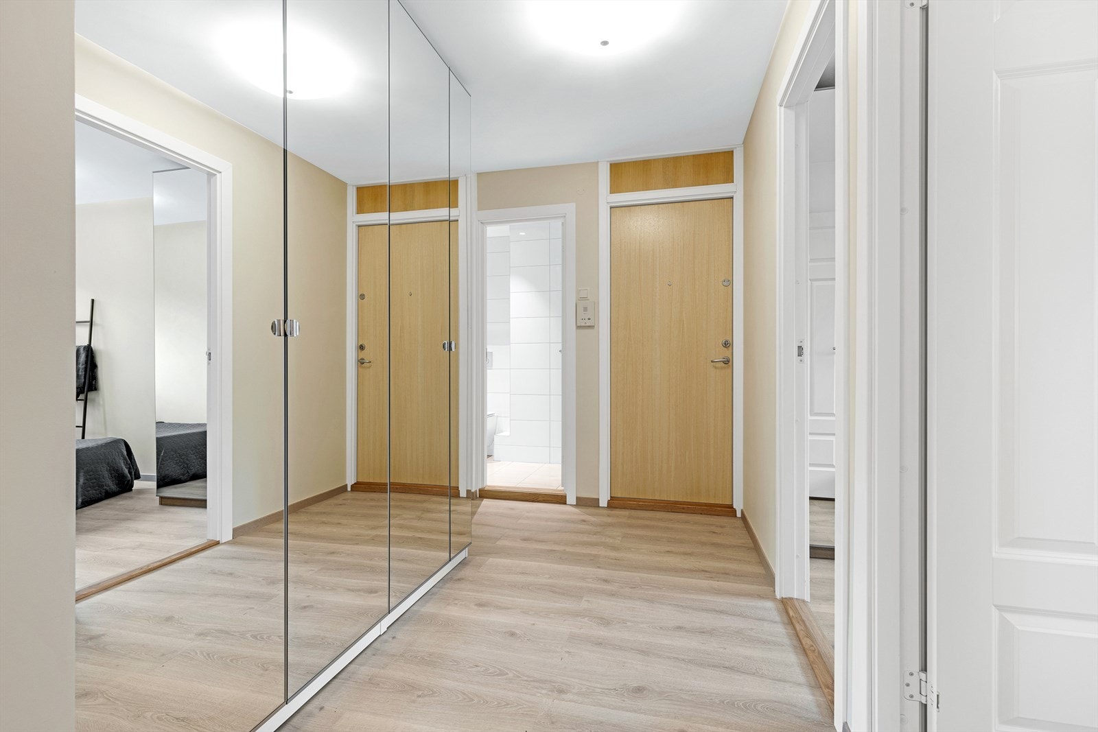Første møte med boligen er en lys og luftig entré. Stor garderobeløsning langs den ene veggen gir rikelig med plass til oppbevaring av sko, yttertøy etc. Galleribilde