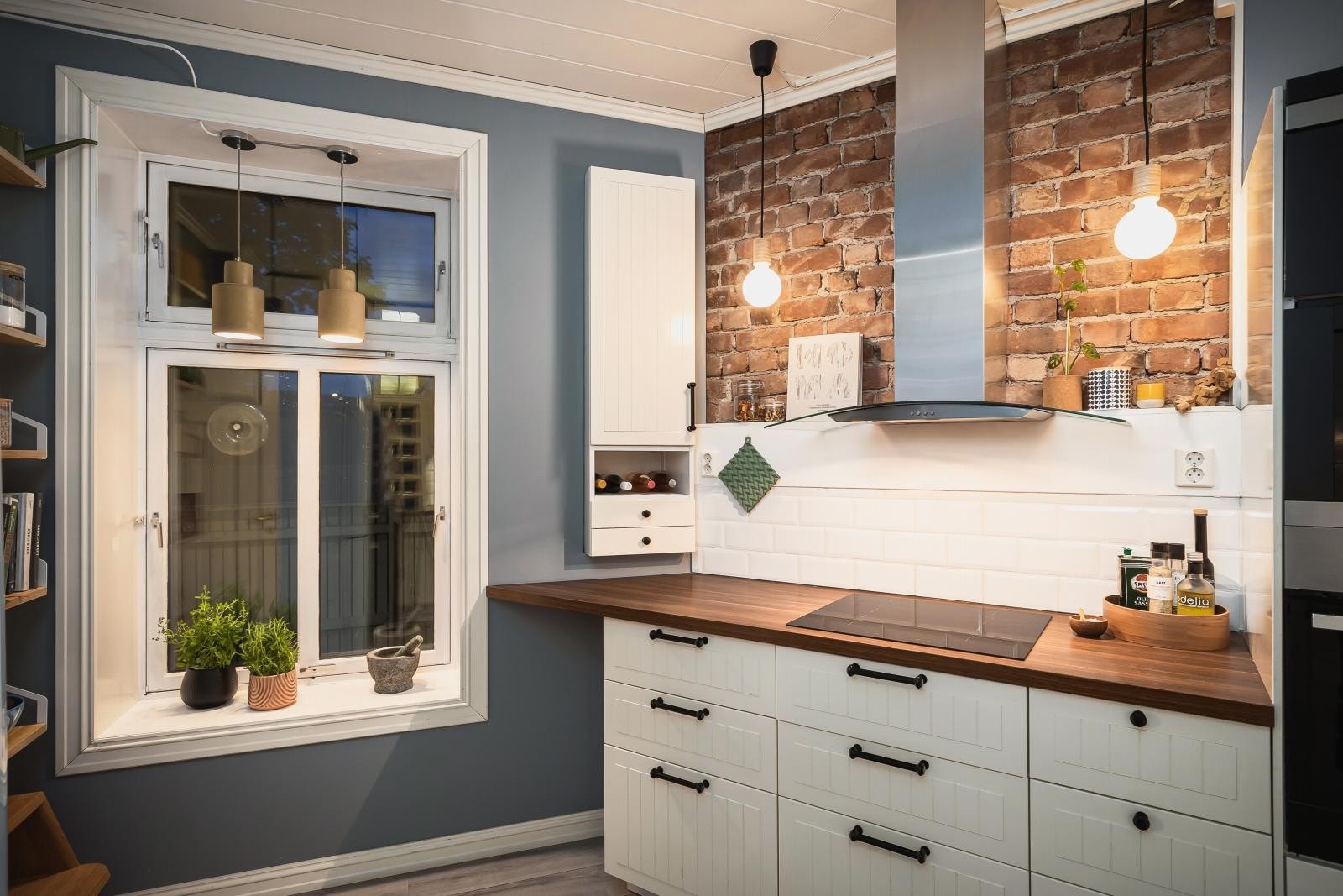 Moderne og koselig kjøkken fra 2013 med bl.a. synlig teglstein, pendellamper og flott flislagt vegg fra 2019. Galleribilde