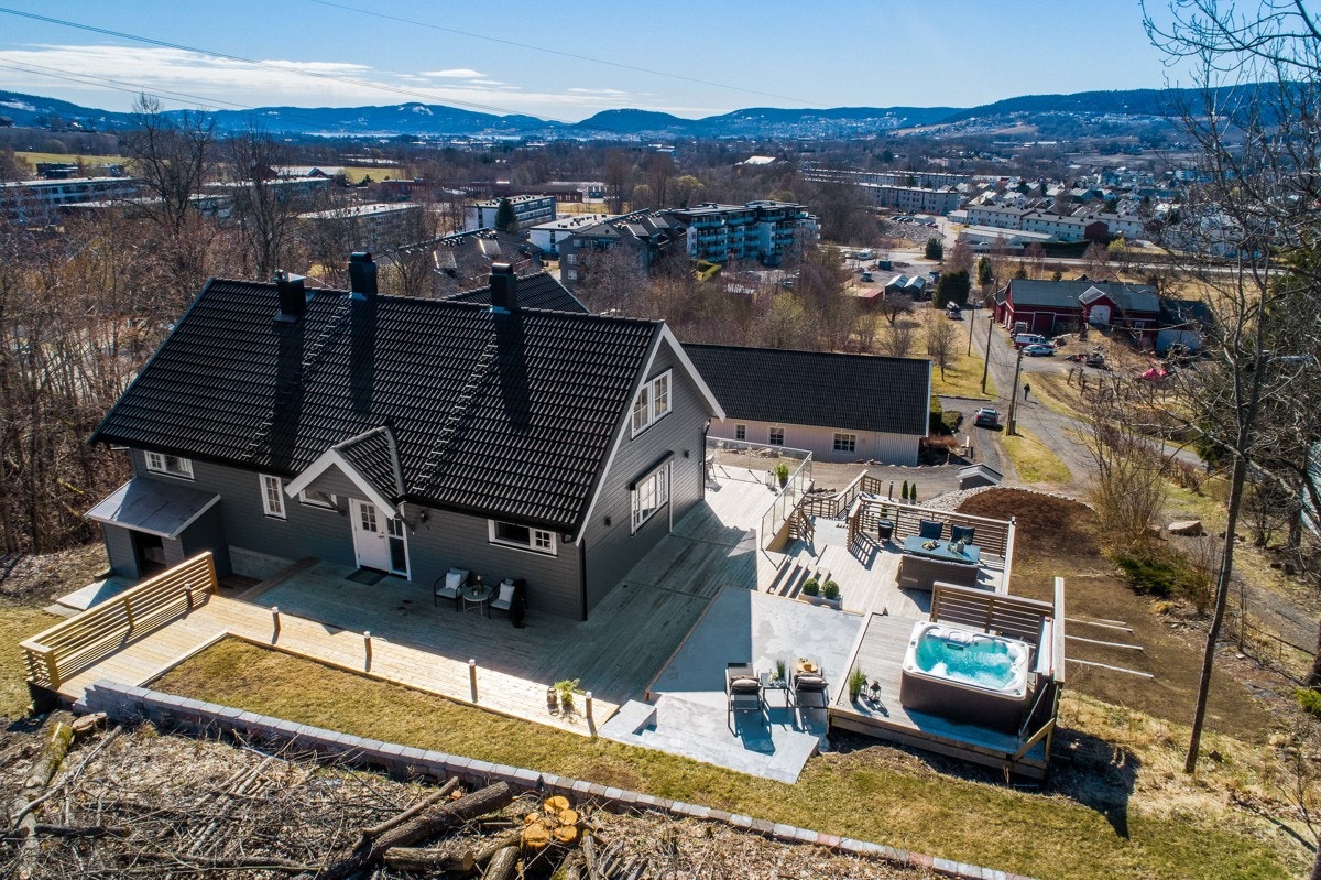 På øvre nivå er det et plen mot støttemur og terrasse med nyere jacuzzi. Galleribilde