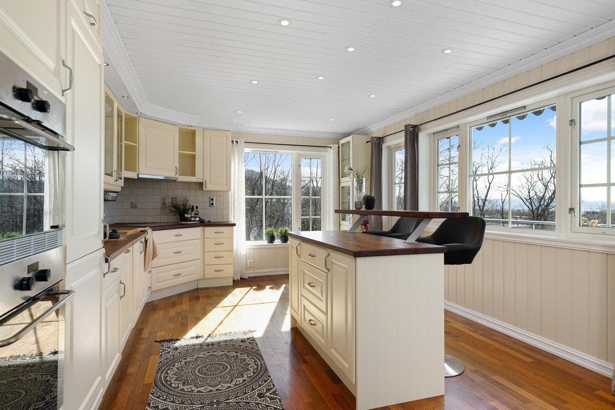 Dagslyset flommer inn via store vinduer og det er utgang til en veranda. Galleribilde