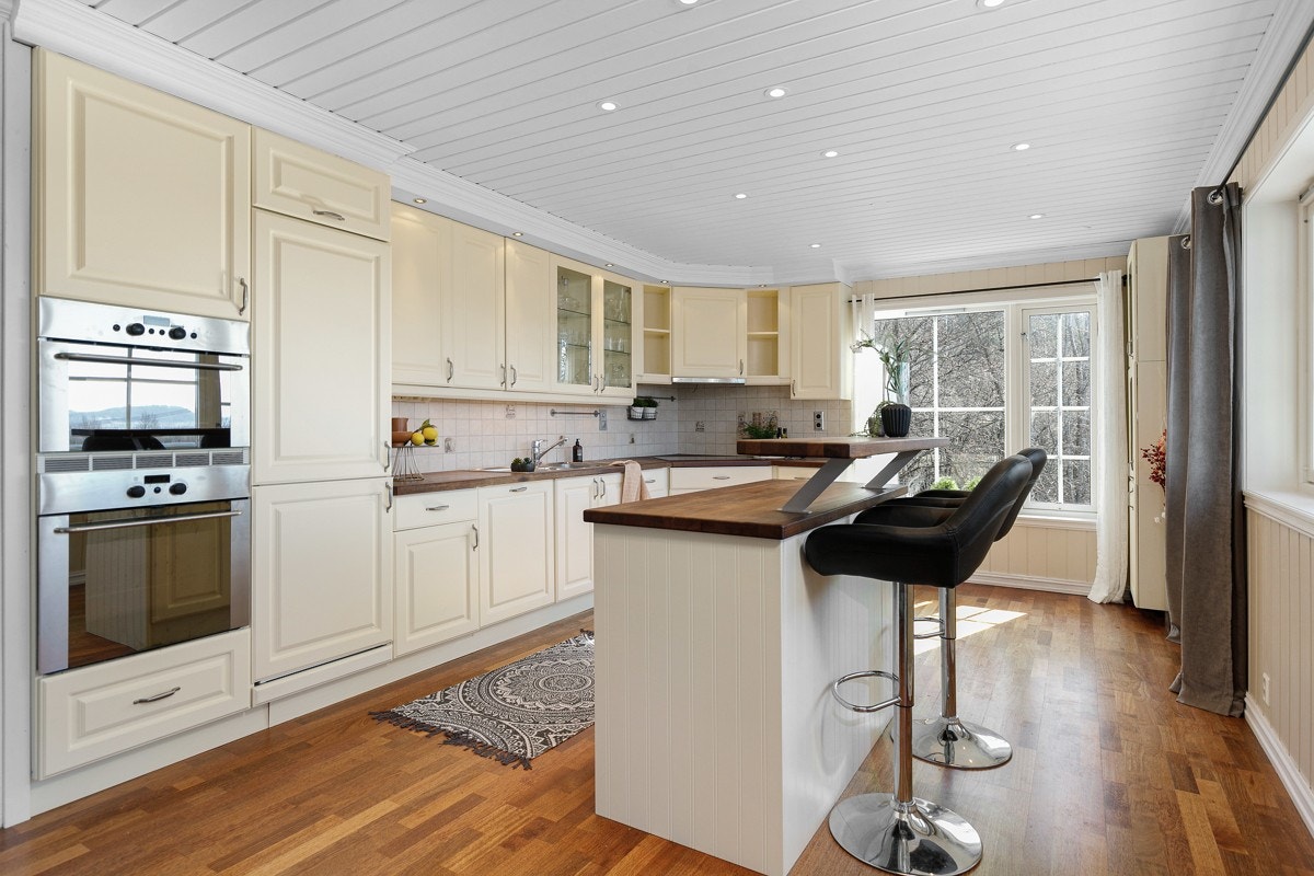 Den har vaniljegule profilfronter og vitrineskap, i fin kombinasjon med heltre benkeplate med nedfelt benkebeslag. Galleribilde