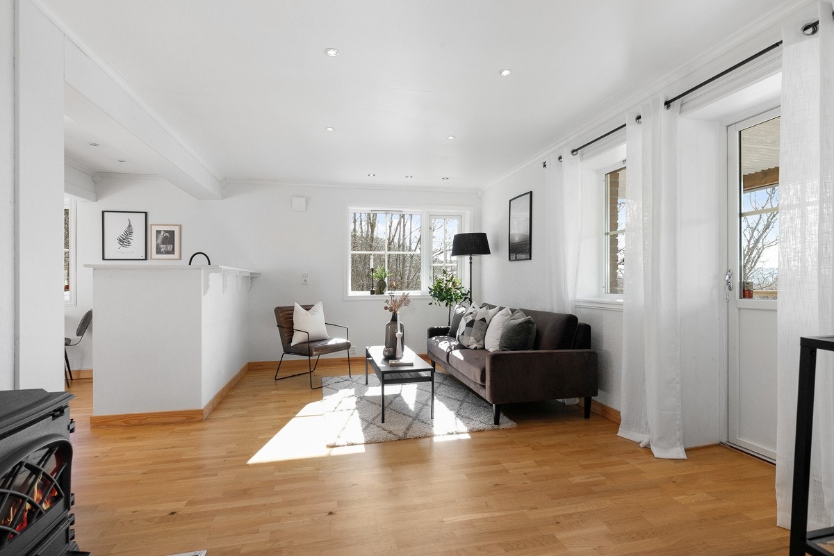 Stuen og kjøkkenet blir tilsammen et lyst og luftig oppholdsrom med parkettgulv og hvitmalte vegger. Galleribilde