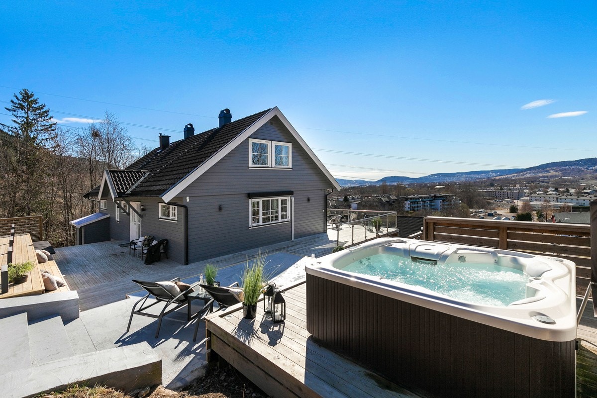 På øvre nivå er det et plen mot støttemur og terrasse med nyere jacuzzi. Galleribilde