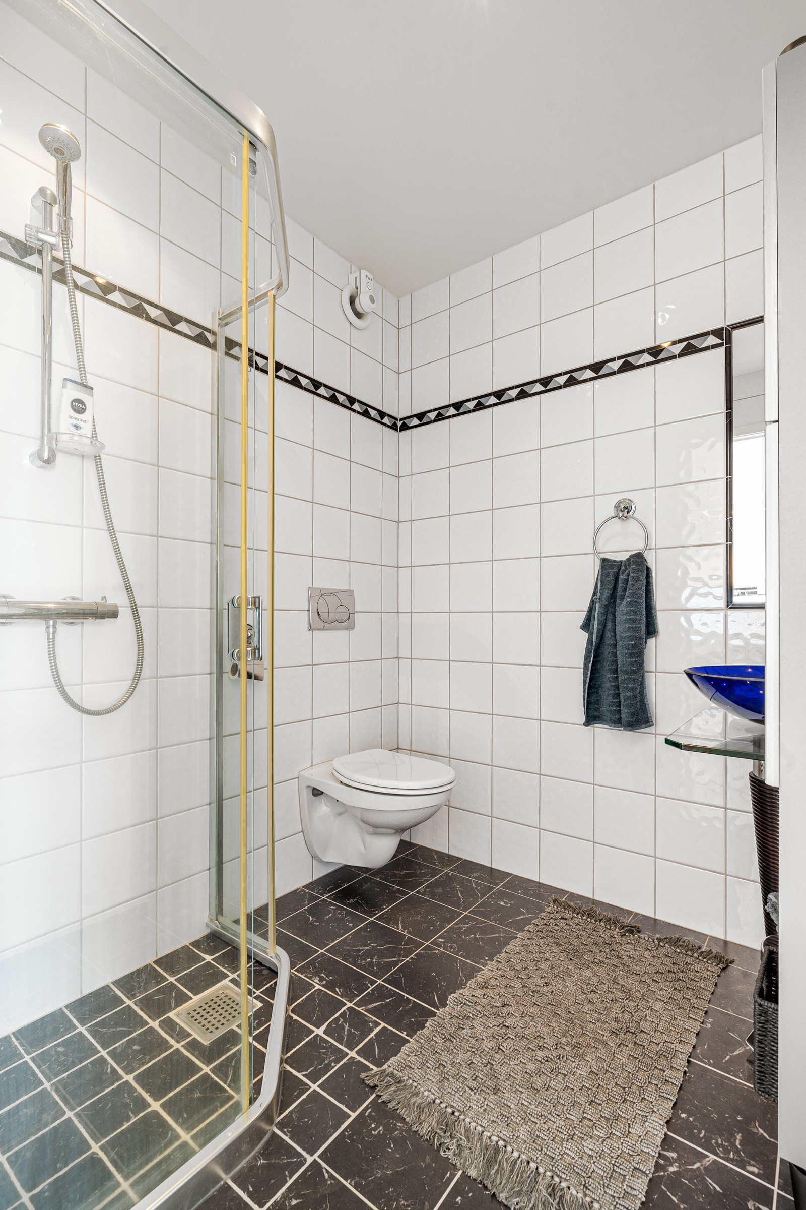 Komplett flislagt bad med gulvvarme - badet er innredet med dusjhjørne, toalett og servant