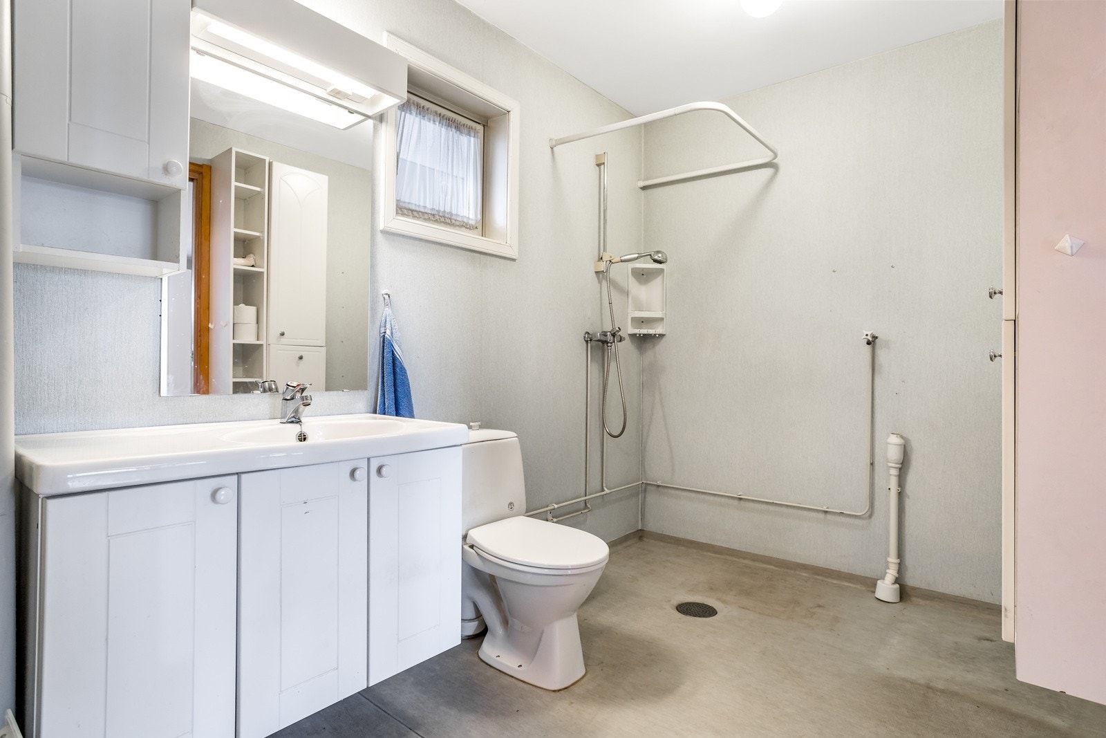 Bad med dusj, toalett, servant i seksjon. Veggskap.Opplegg for vaskemaskin Galleribilde