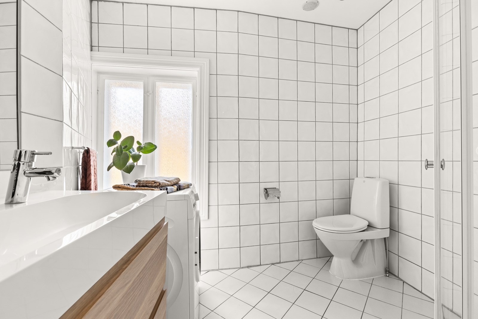 Flislagt bad med varmekabel, nytt dusjhjørne, wc og dobbel servantseksjon med skuffer for oppbevaring. Galleribilde