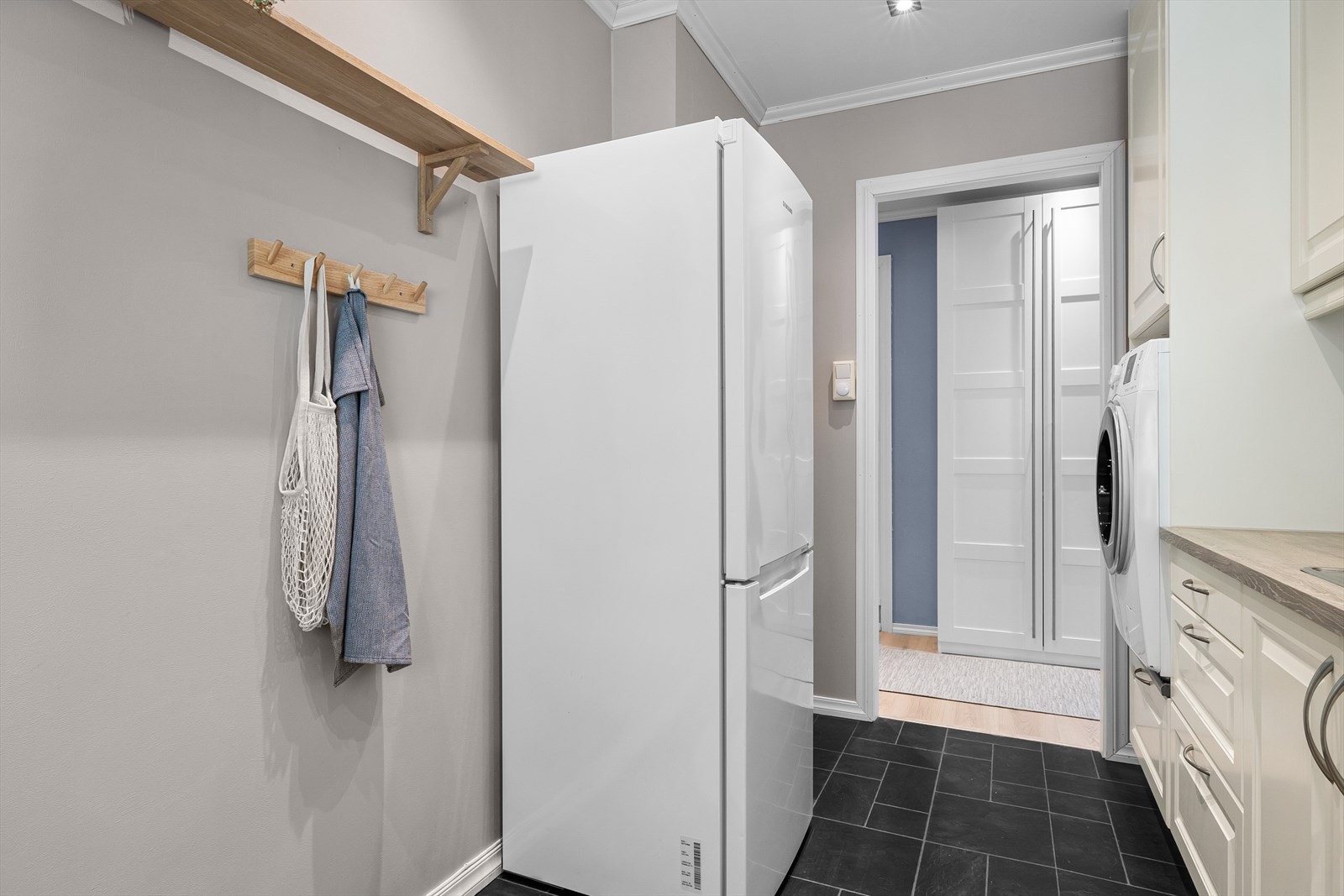 Fine fliser over benkeplate og opplegg for oppvaskmaskin. Kjøkkenet har ellers godt med både skap- og benkeplass Galleribilde