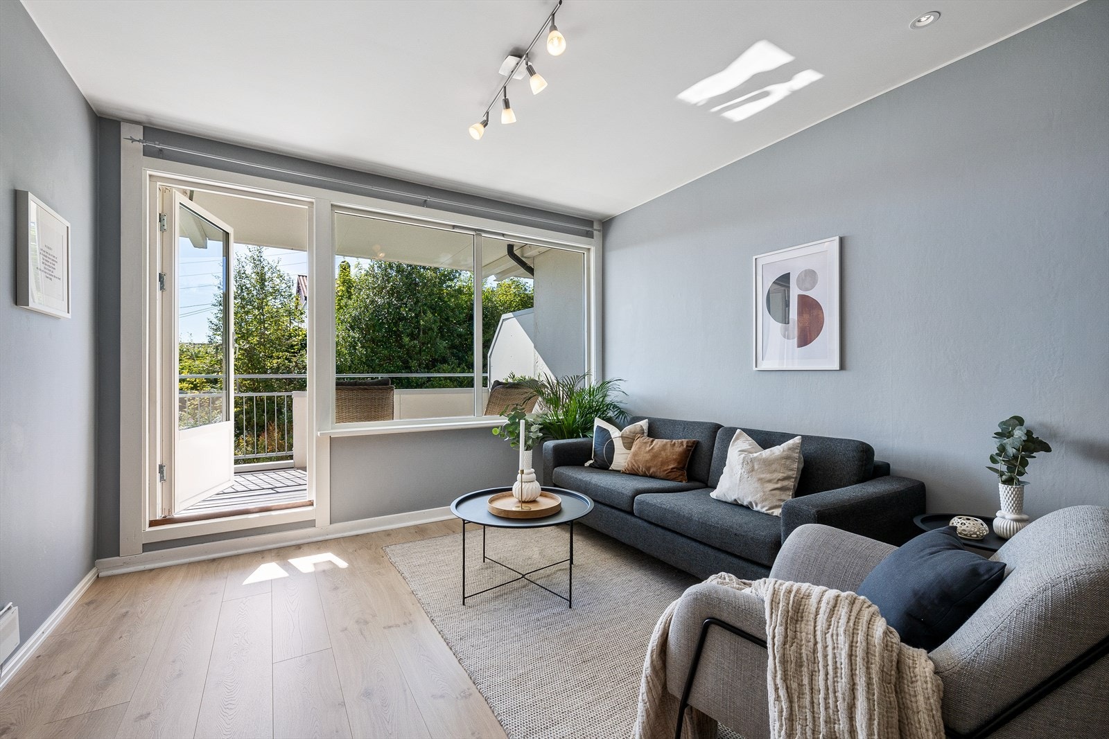 Lys og pen stue med laminat på gulv og vegger malt i en nydelig farge Galleribilde