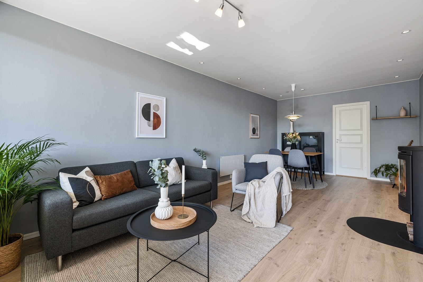 Store vindusflater gir godt med naturlig lysinnslipp i stuen, og en koselig vedovn gir godt med varme på kalde dager Galleribilde