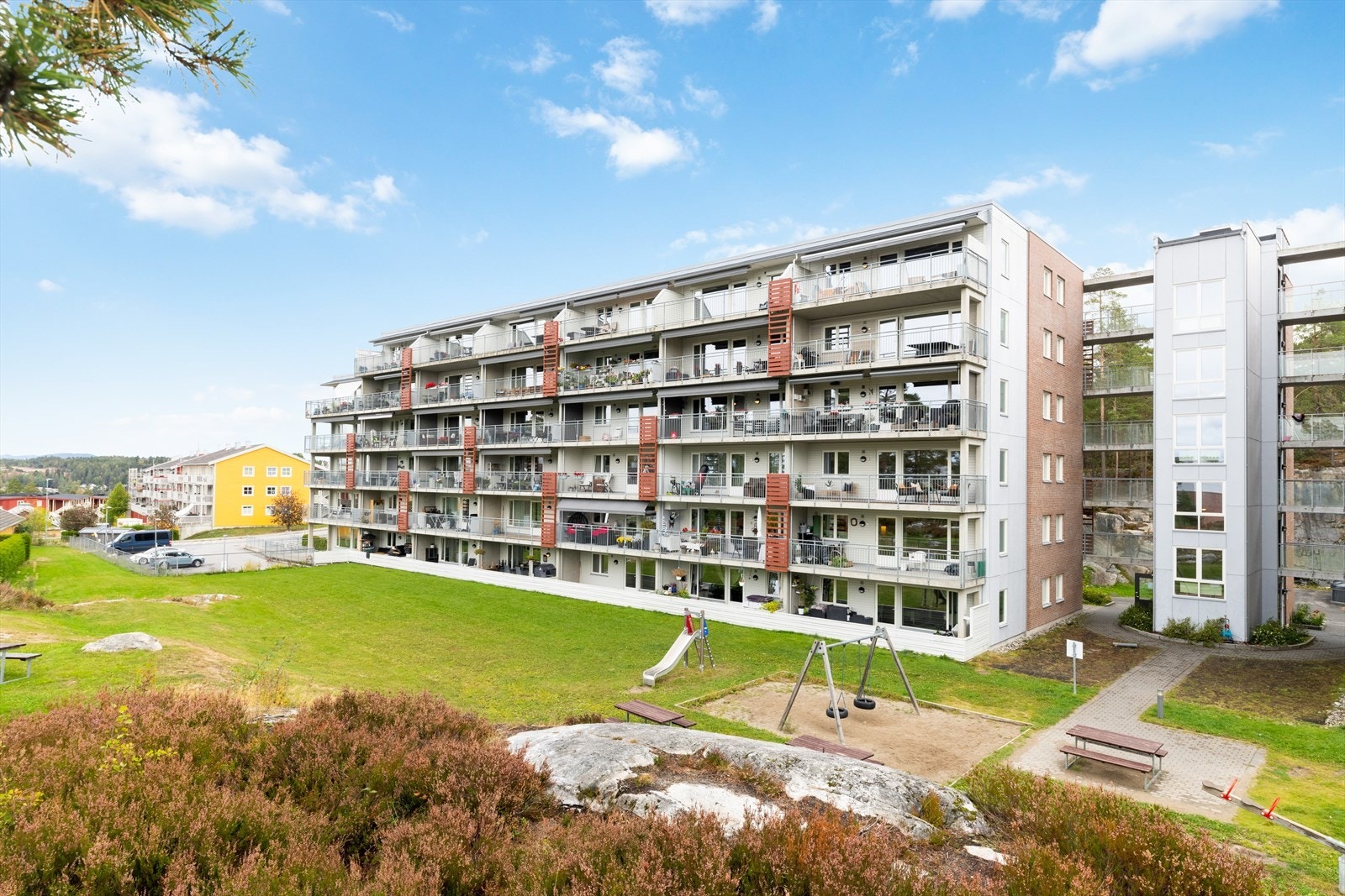 Flotte fellesarealer med lekeplass for barna og sittegrupper for de voksne. Galleribilde