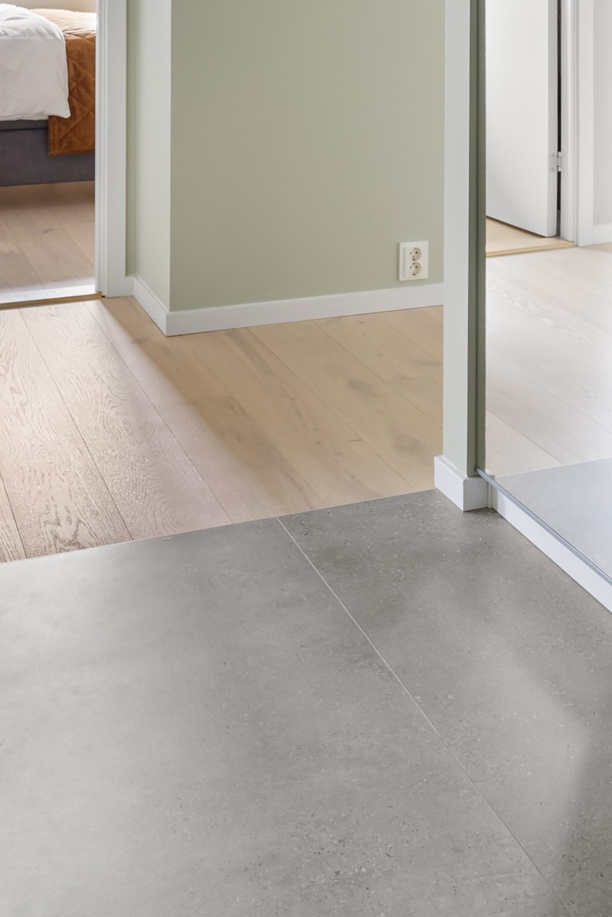 Strøken overgang mellom flis og parkett - I denne leiligheten er det enkelt å se at det er lagt stor vekt på både estetikk og praktisk utforming Galleribilde