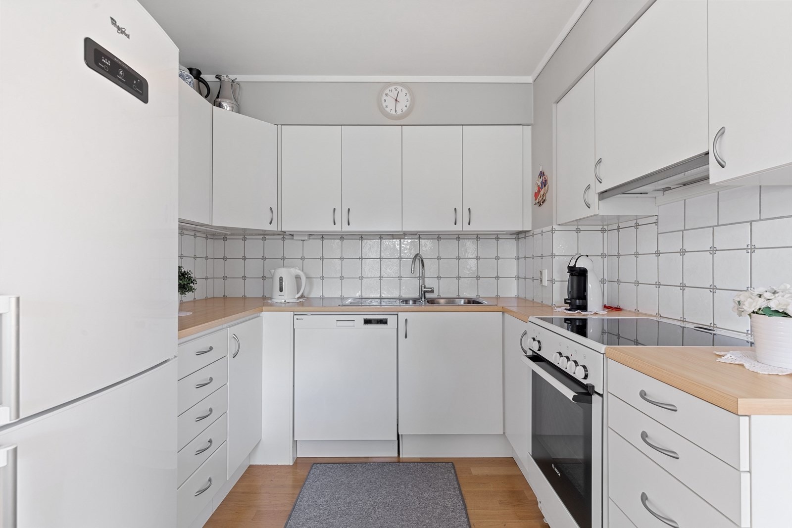 På veggflaten mellom kjøkkenbenken og overskapene er det fliser. Av hvitevarer medfølger komfyren, kjøleskap og oppvaskmaskinen. Galleribilde