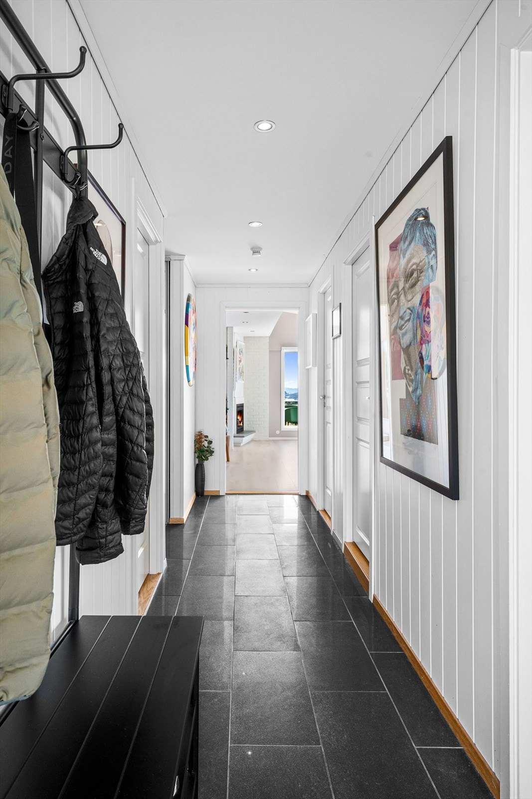 Entréen har plass til jakkeknagger og skostativ. Det er fliser på gulv og downlights i himling Galleribilde