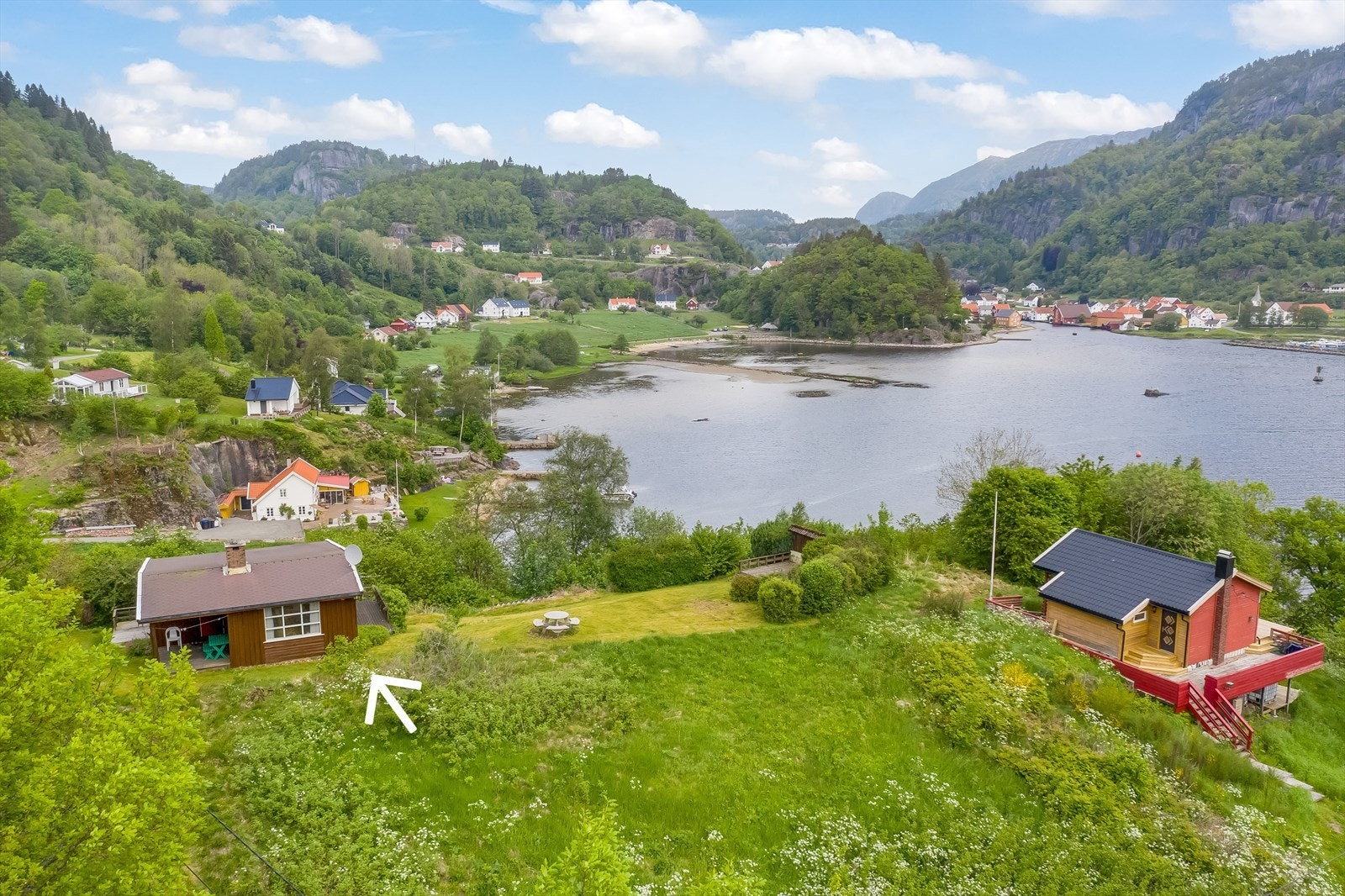 Fritidseiendommen ligger på en liten høyde på Sande blant spredt hyttebebyggelse. Galleribilde