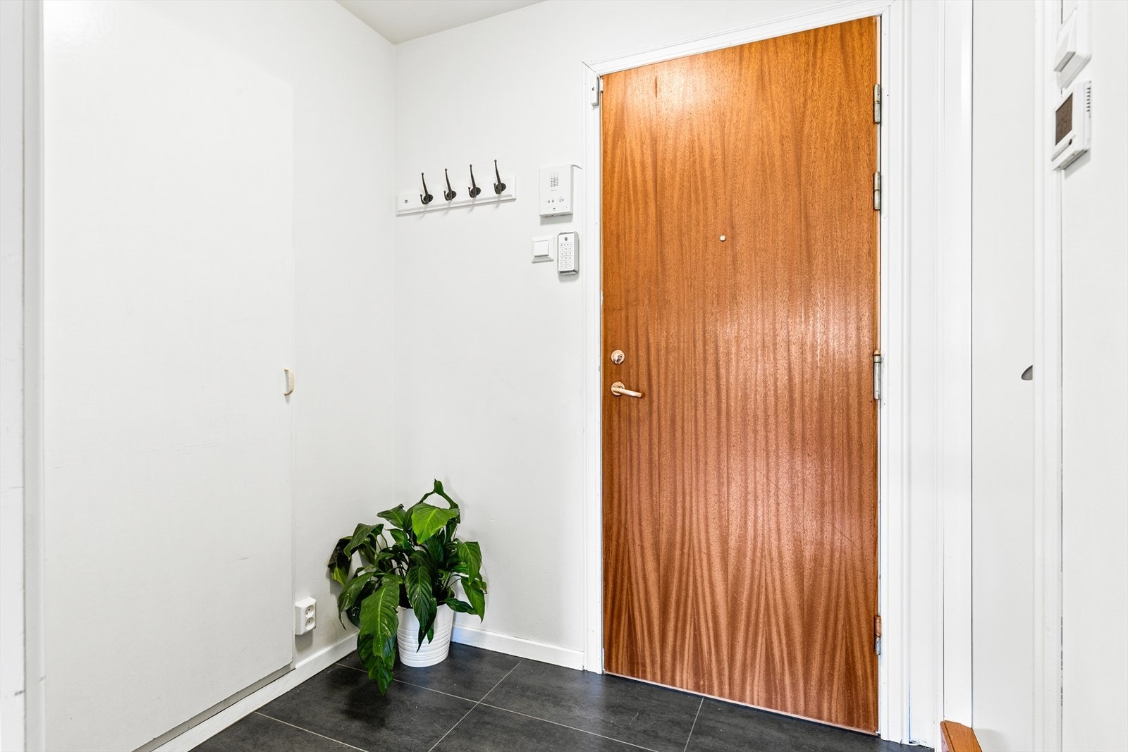 Entreen gir boligen et godt førsteinntrykk. Det er plass til å legge fra seg skoene og henge fra seg yttertøy før man går videre inn i leiligheten. Galleribilde