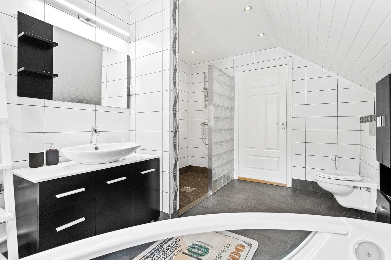 Baderomsinnredningen består av en skapløsning med toppmontert servantskål og et speil med belysning. Galleribilde