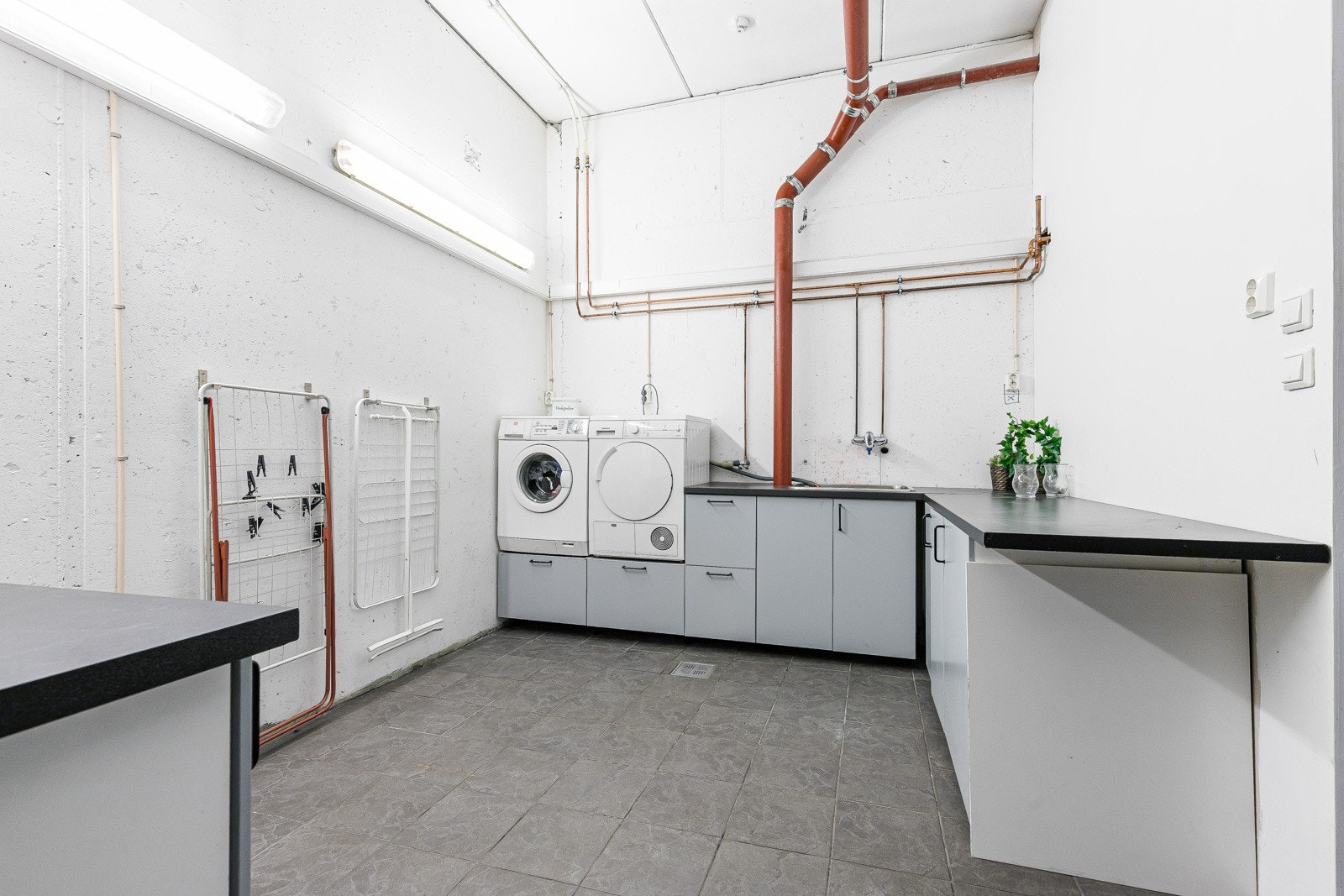 Vaskerommet er innredet med grå gulvfliser, gulvvarme og hvitmalte murvegger. Galleribilde