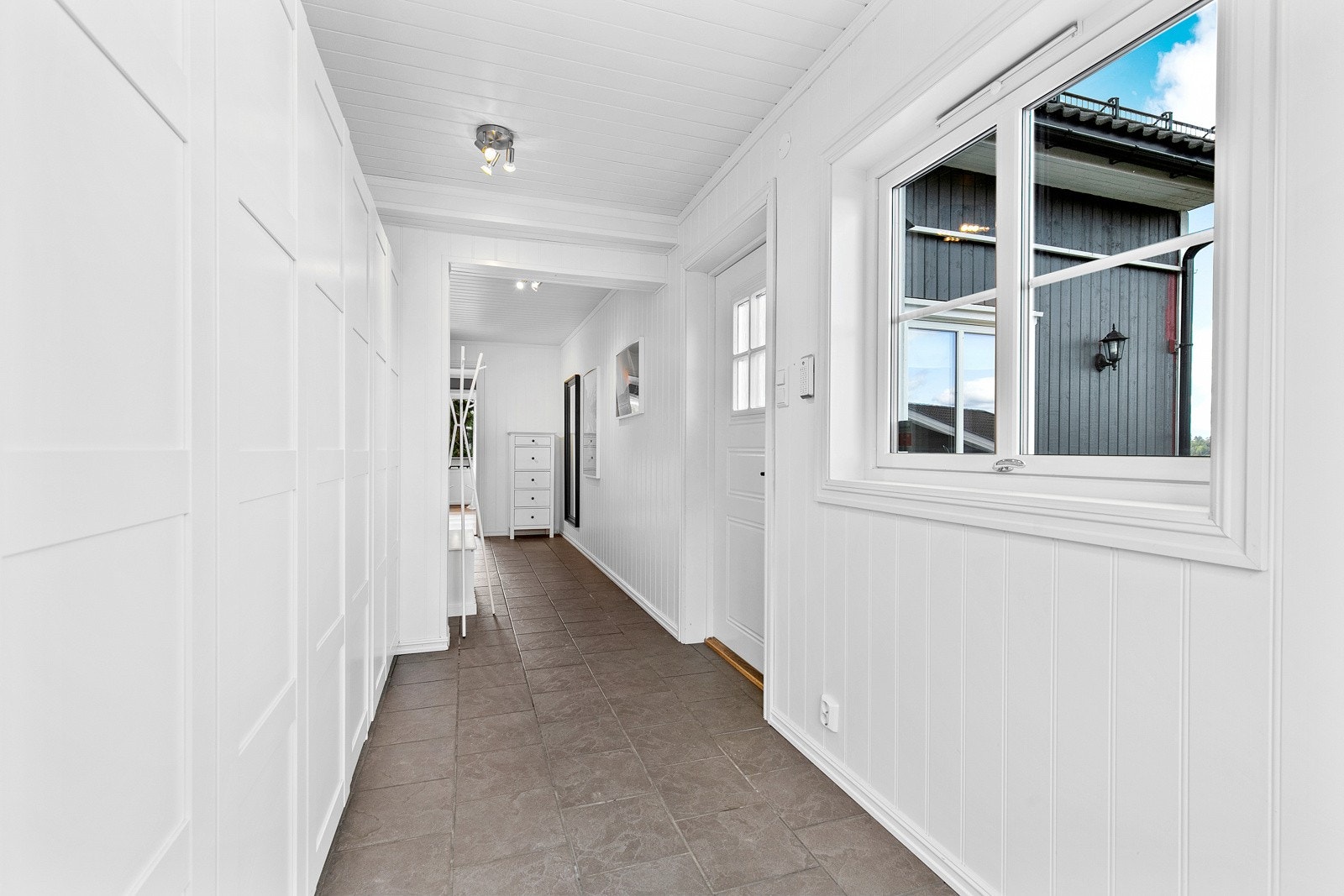 Entreen er romslig og meget innbydende, med grå fliser på gulvet. Galleribilde