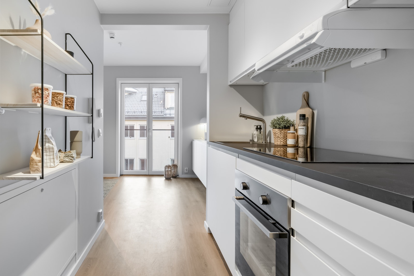 Moderne kjøkken med integrert stekeovn, induksjonstopp, oppvaskmaskin og kjøl/frys Galleribilde