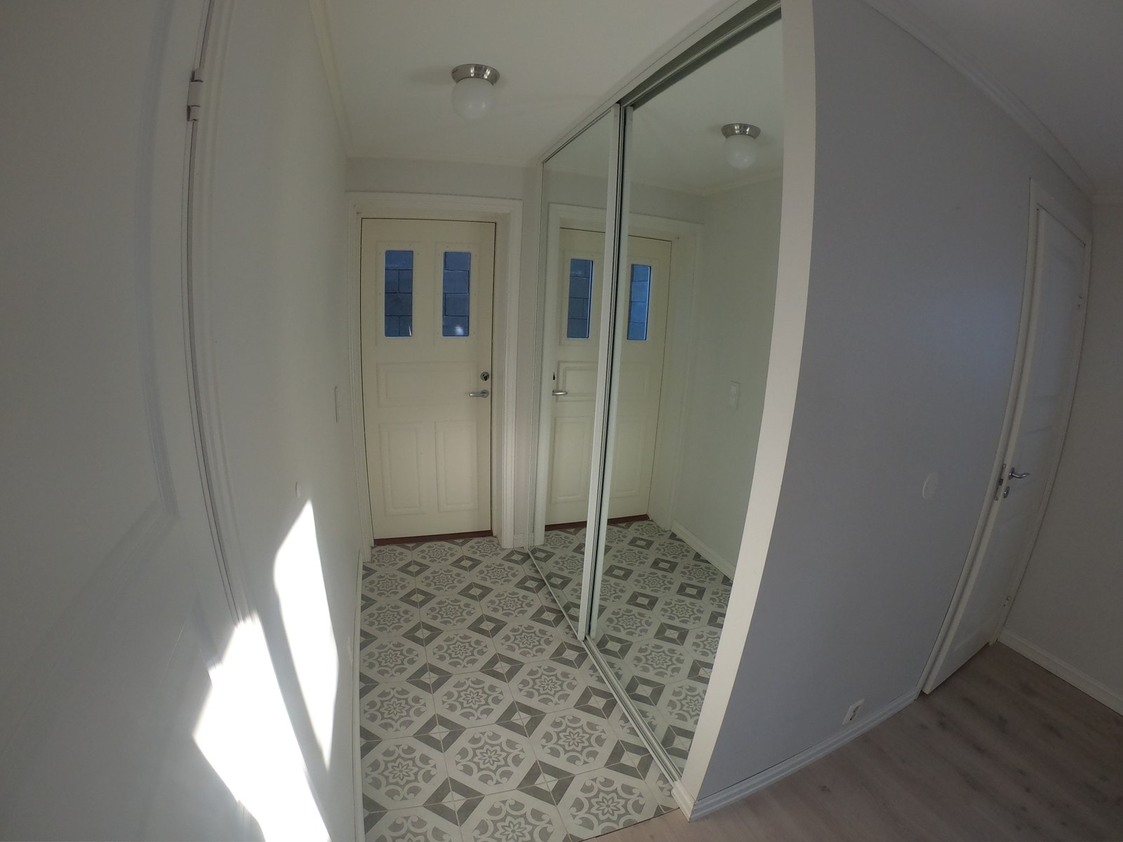 Flislagt inngangsparti med skyvedørsgarderobe Galleribilde