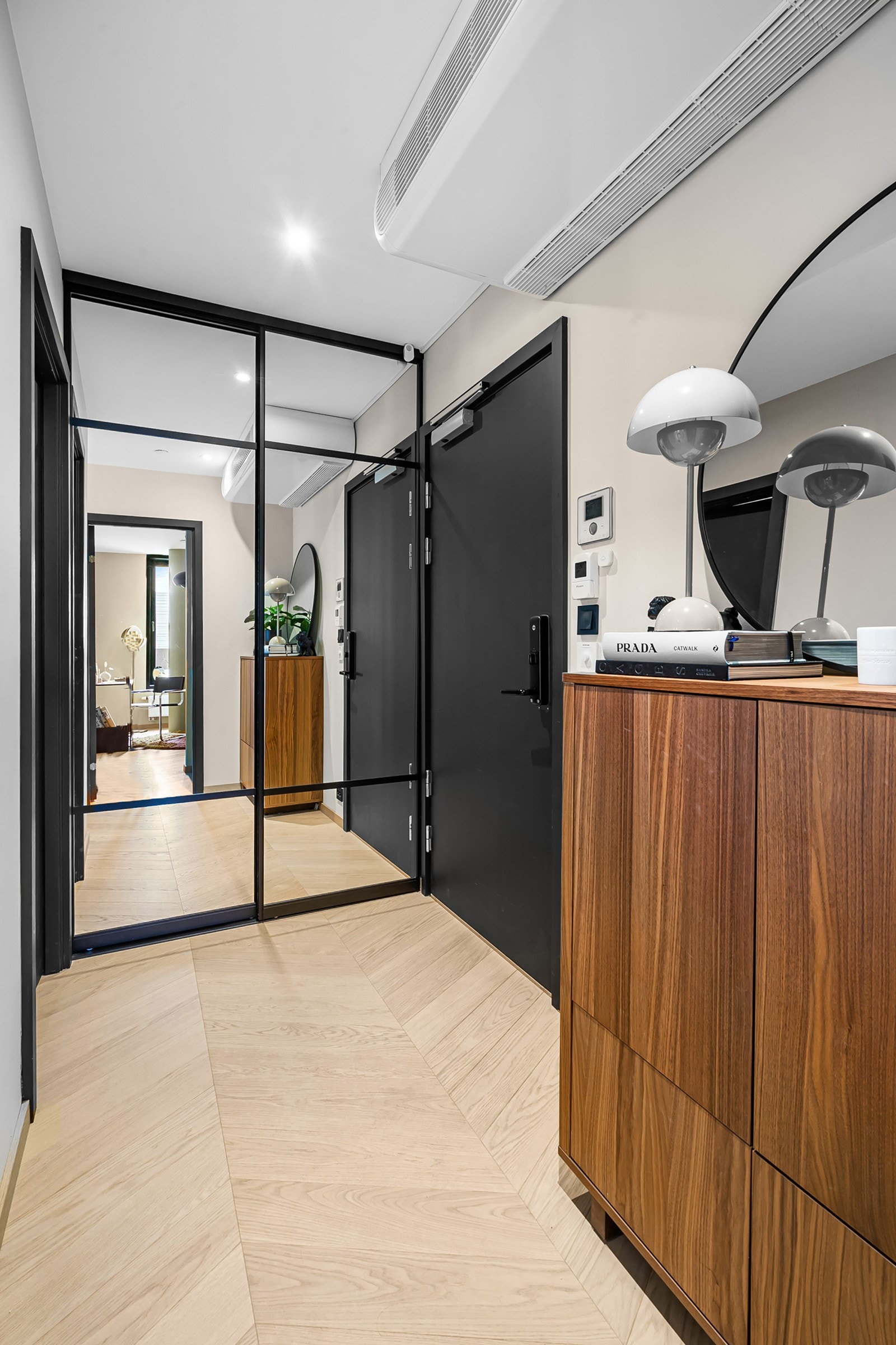 Himling er pent lyssatt med downlights, og en skyvedørsgarderobe med speil og mørk innramming holder orden på yttertøy og sko. Galleribilde