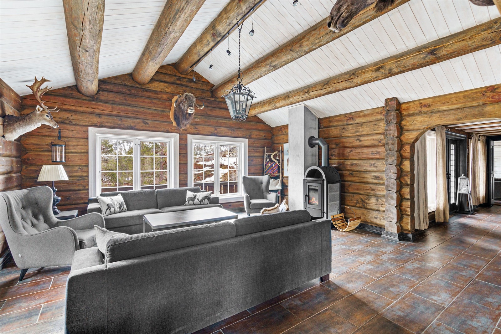 Stue med peisovn og god takhøyde. Utgang terrasse til høyre. Galleribilde