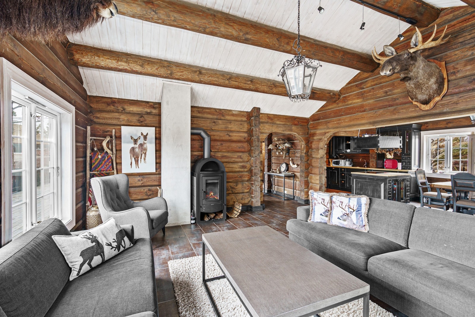 Stue med peisovn og god takhøyde Kjøkken og spiseplass i bakkant. Galleribilde