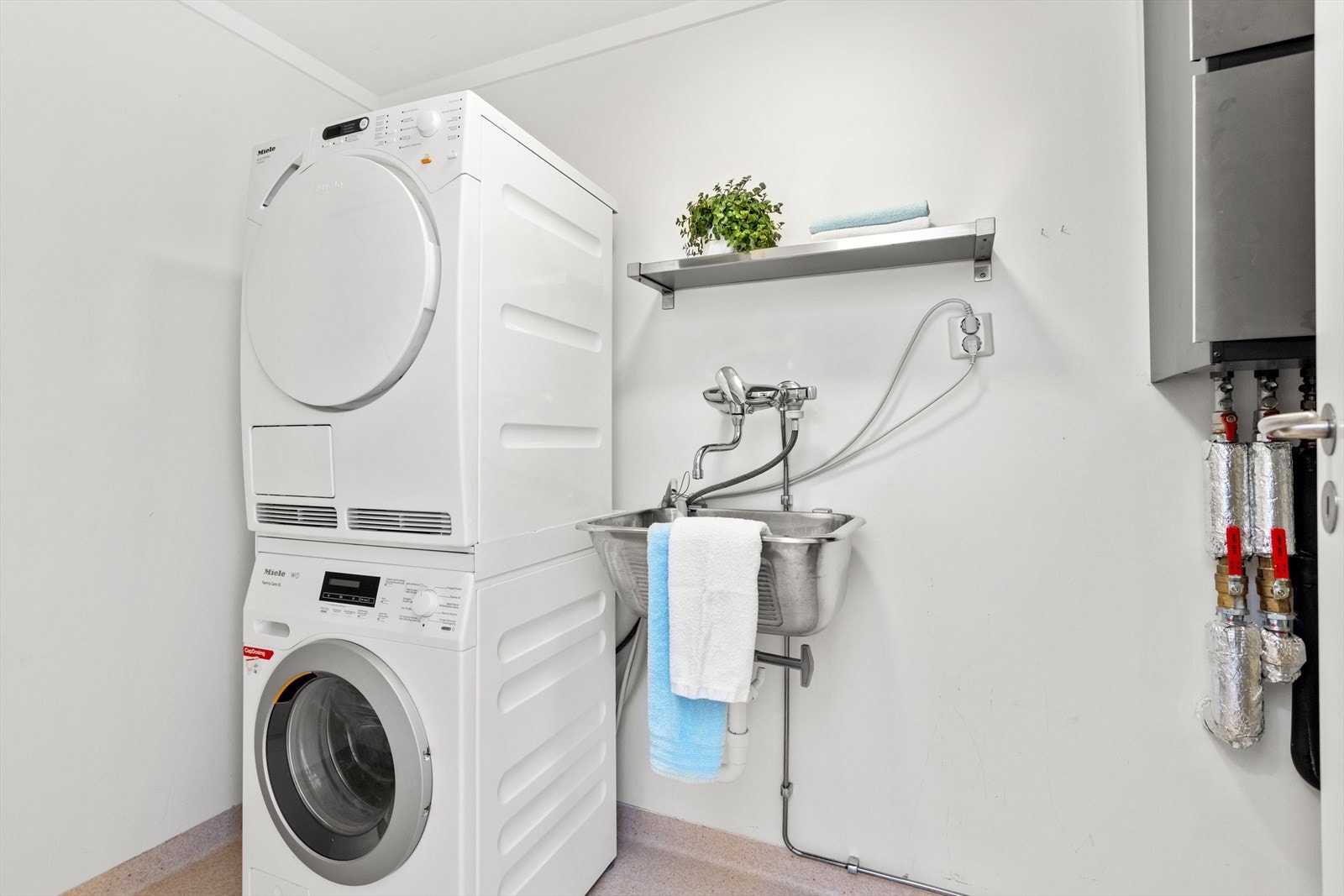 Vaskerom med gulvvarme og toalett. Utstyrt med rørfordelingsskap, mekanisk avtrekk, skyllekum, opplegg for vaskemaskin og fjernvarme fordeling. Galleribilde